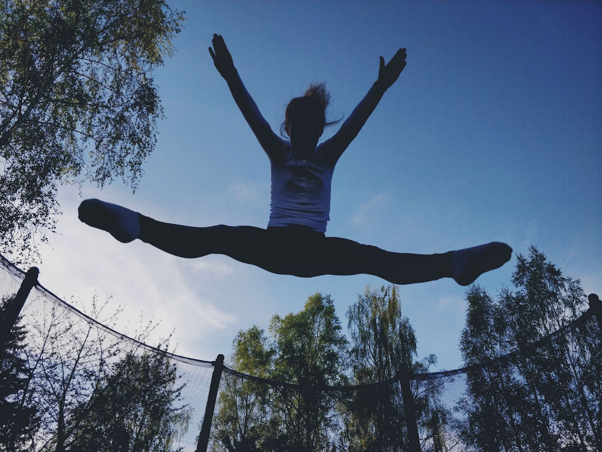 girl jumping on a trampoline in summer