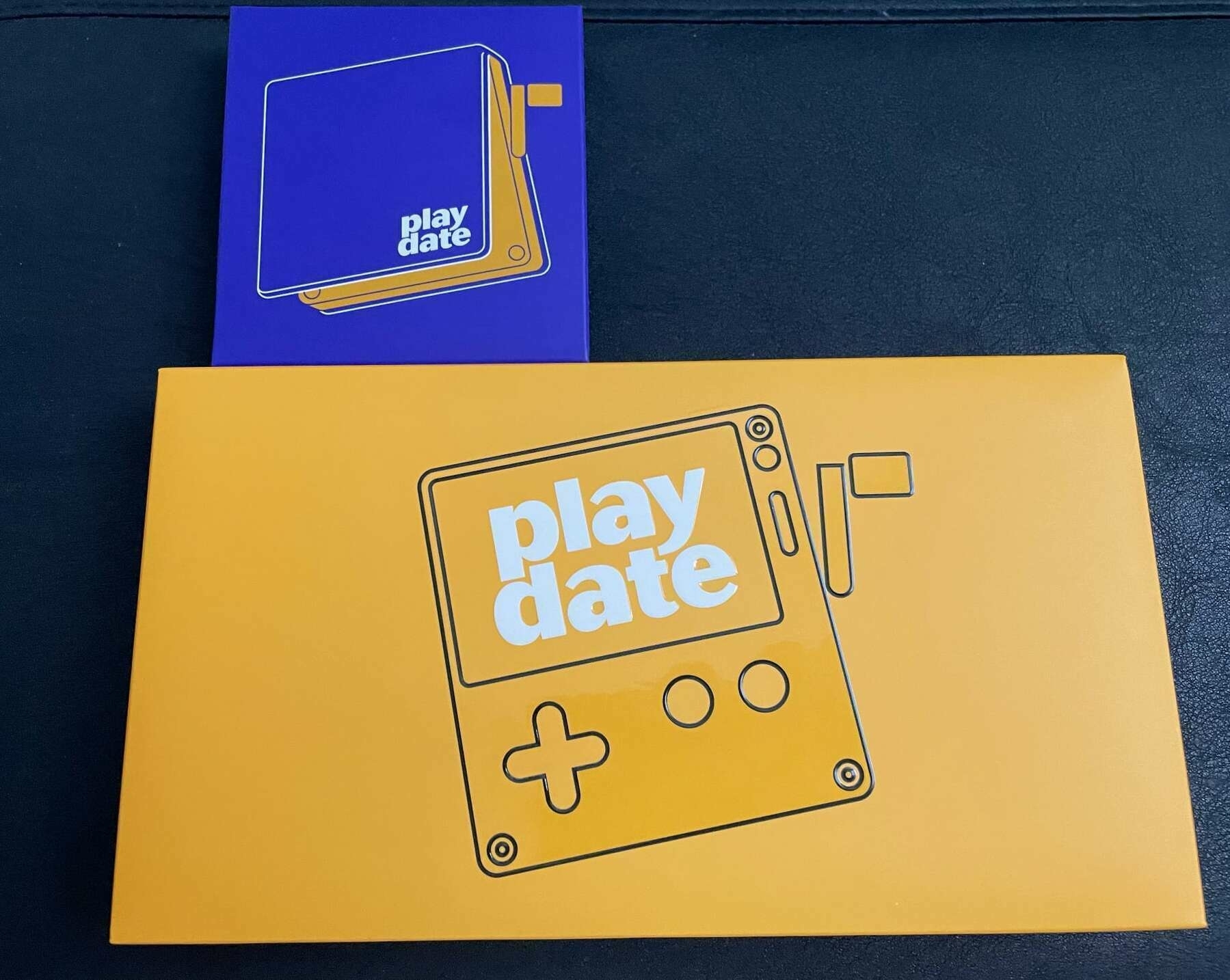 boxed Panic! play date console [yellow with white lettering] and cover [purple with white lettering] on a black background