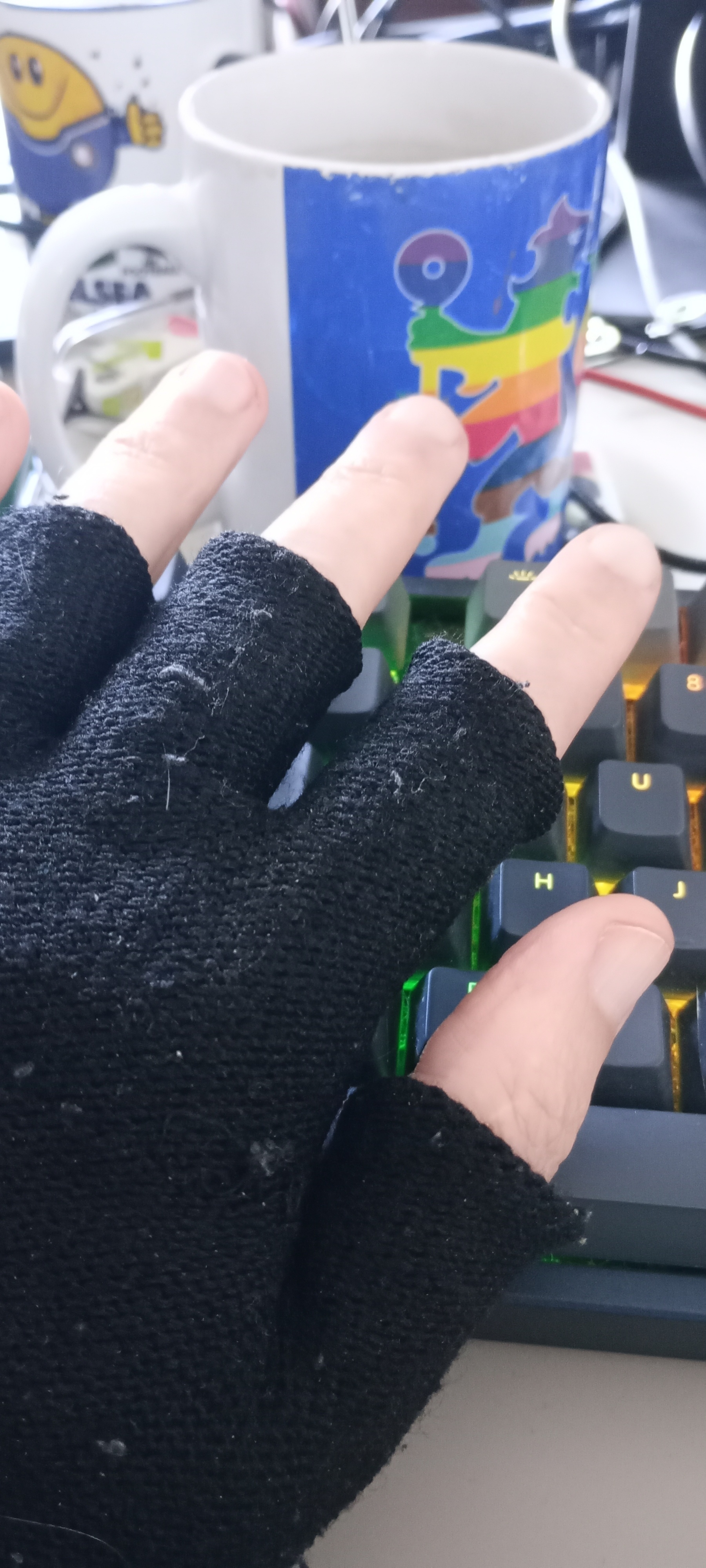 fingerless gloves hand poised over a keyboard