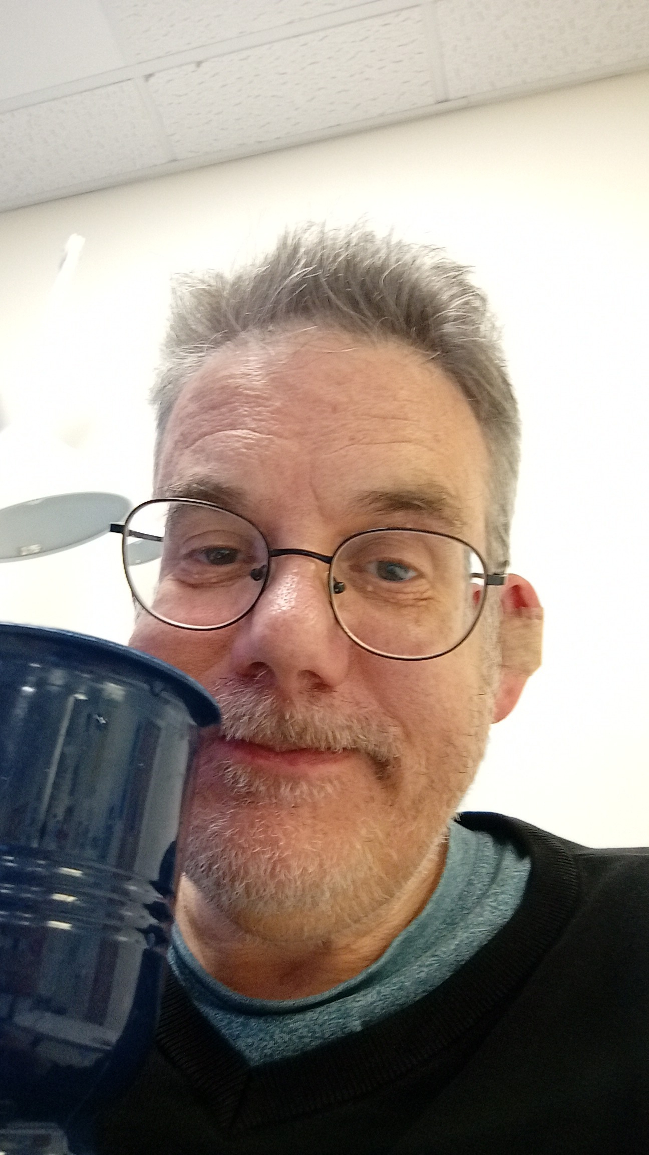 A very handsome bloke with a slightly iffy NHS coffee and a plaster on his ear