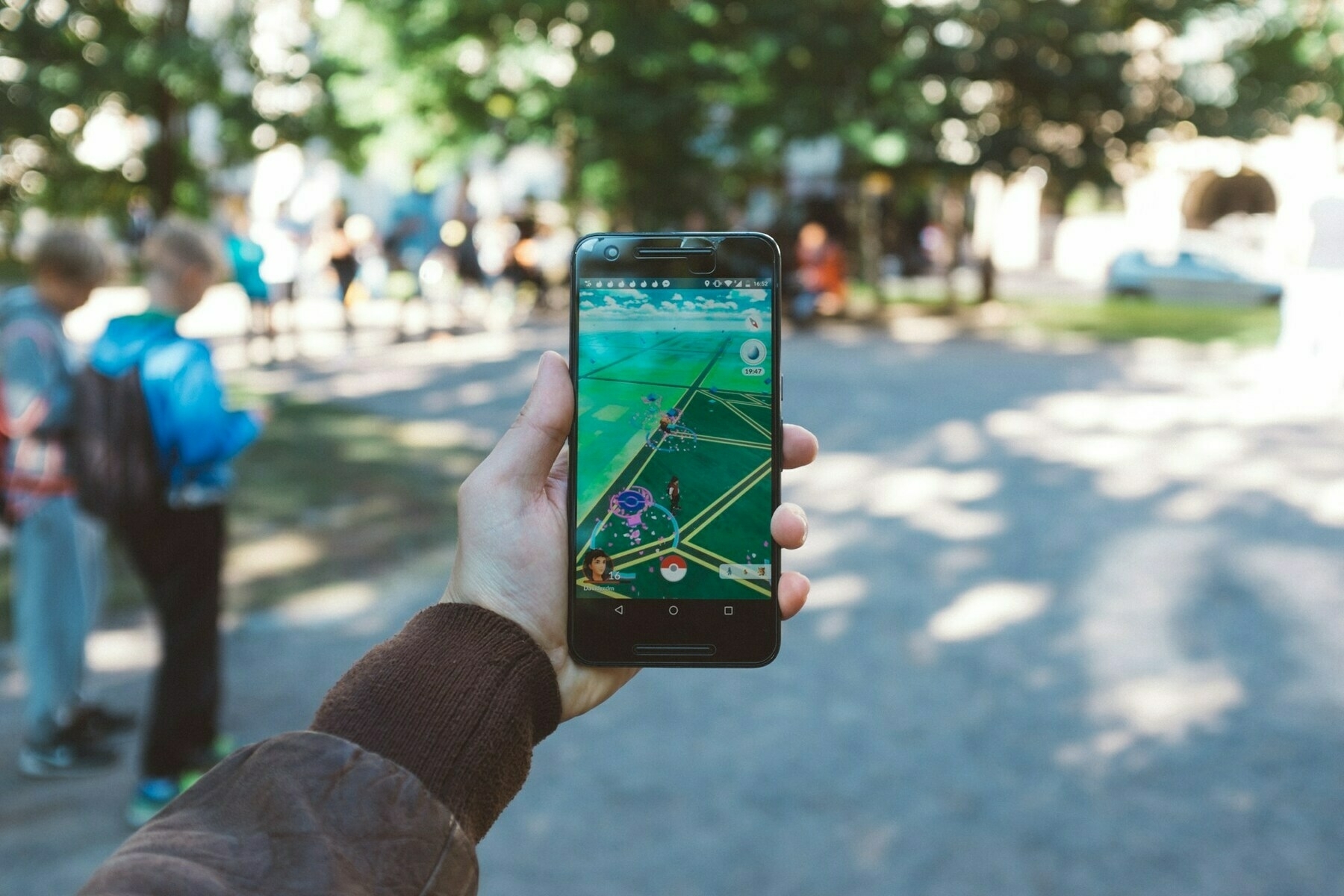 Photograph of someone holding a smartphone, playing Pokemon Go