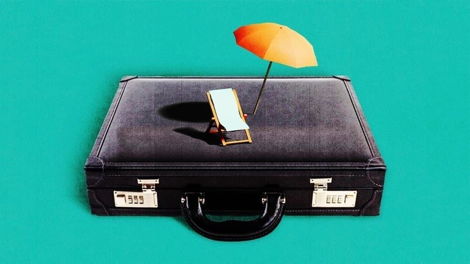 A black briefcase on a teal background, topped with a whimsical miniature beach umbrella and chair setup.