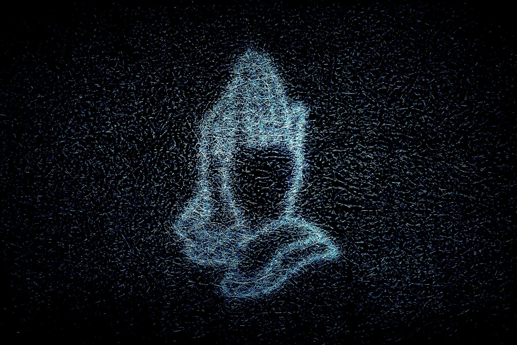 Neon sign of praying hands seen through a fibreglass window