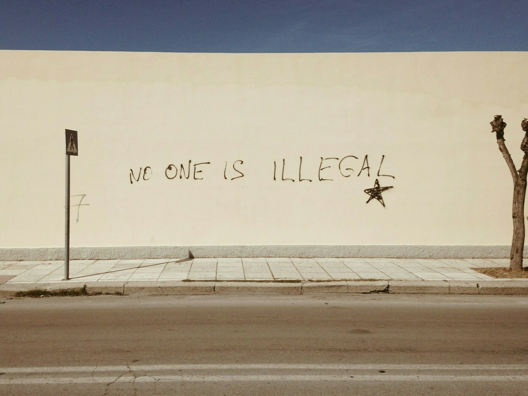 Grafitti saying 'no one is illegal'.