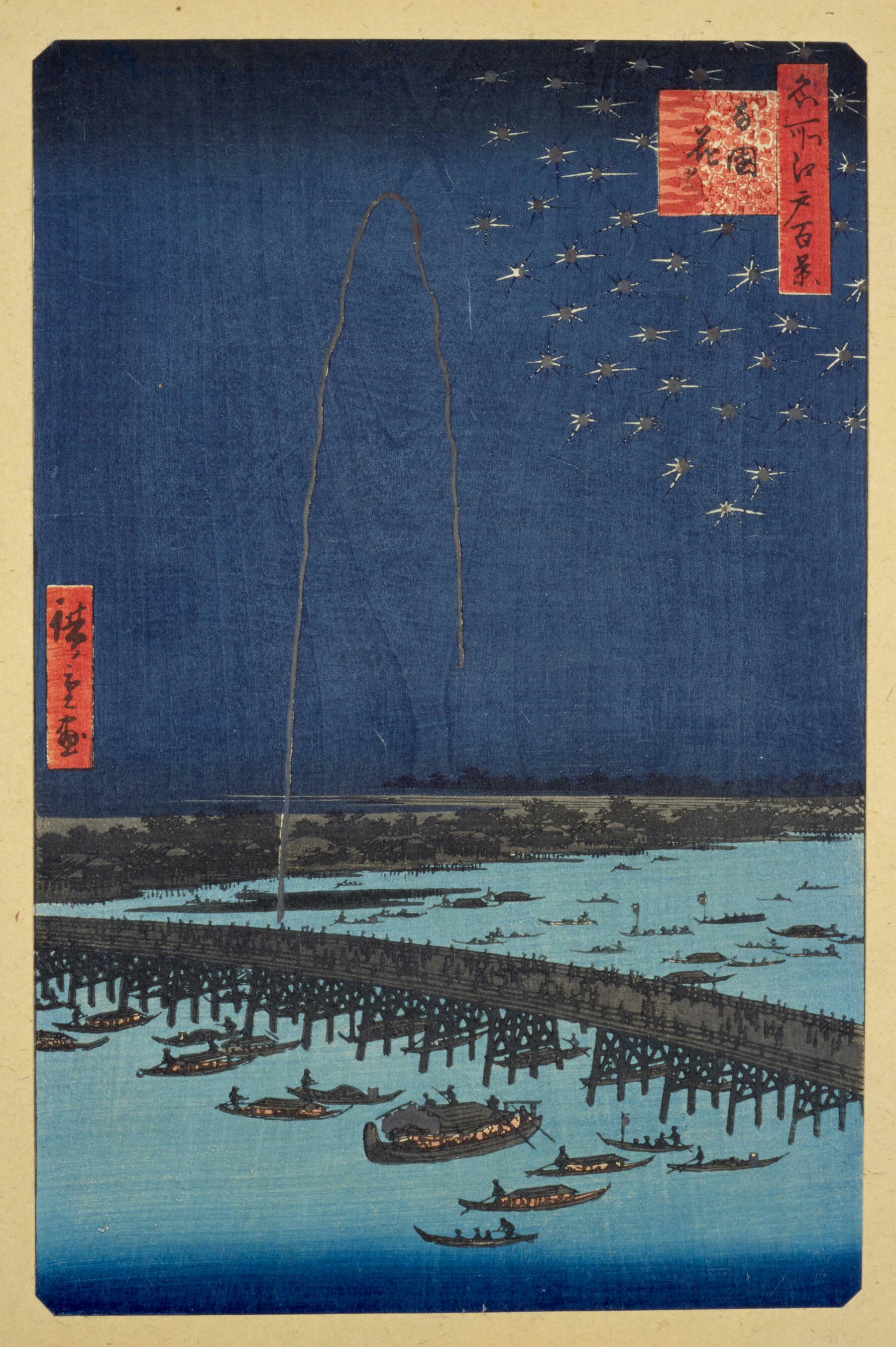 Auto-generated description: A vibrant ukiyo-e print depicting a busy river scene with boats under a wooden bridge at night, featuring a skyrocketing firework and a flurry of smaller bursts against a deep blue sky.