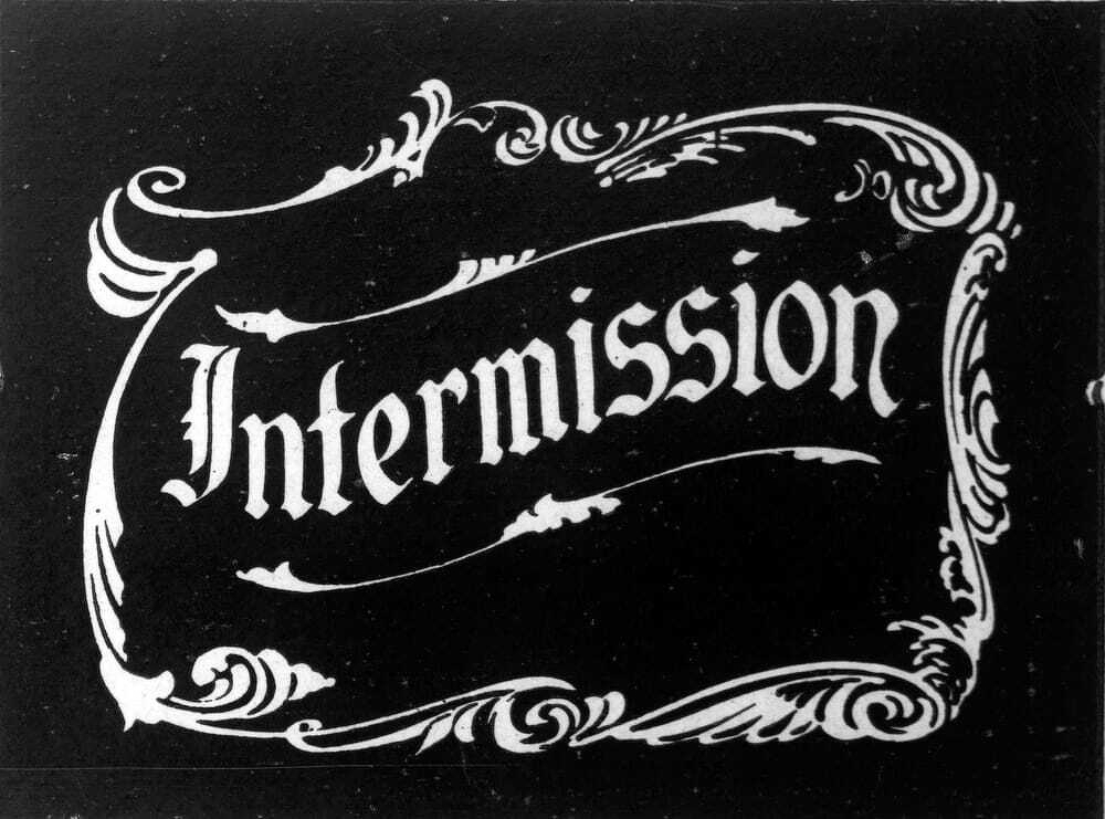 Auto-generated description: The word Intermission is displayed in an ornate white script surrounded by decorative floral designs on a dark background.