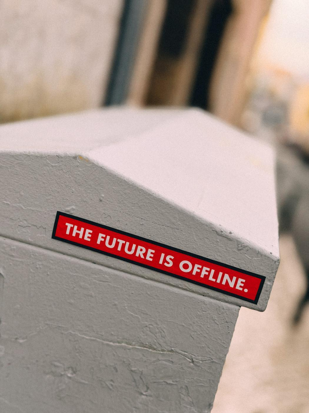 Auto-generated description: A red sticker on a gray surface reads THE FUTURE IS OFFLINE.