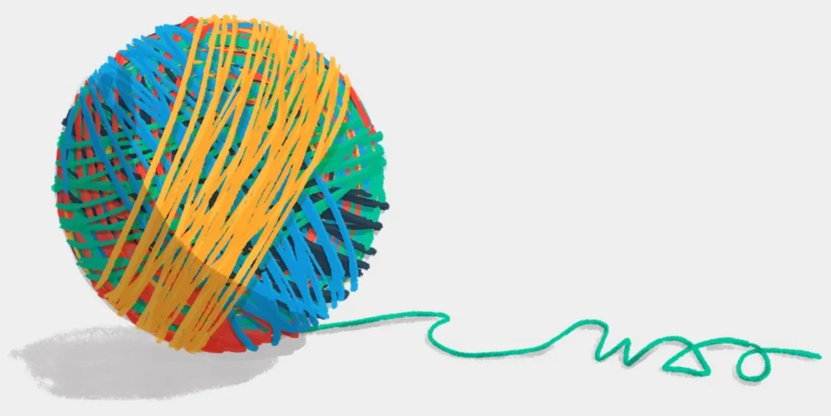 Auto-generated description: A large ball of yarn is wrapped in various colors, including blue, yellow, green, and red, with a green thread extending out to spell 'WAO'.