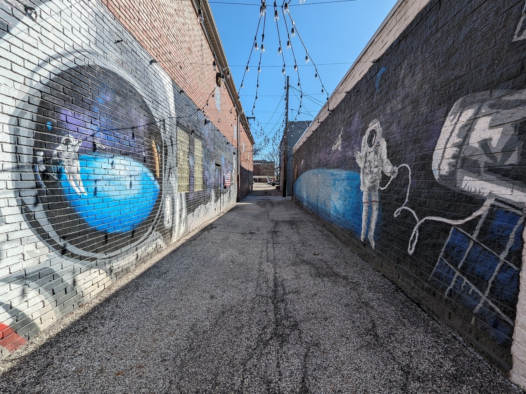 An alleyway with murals of astronauts in space flanking either side.