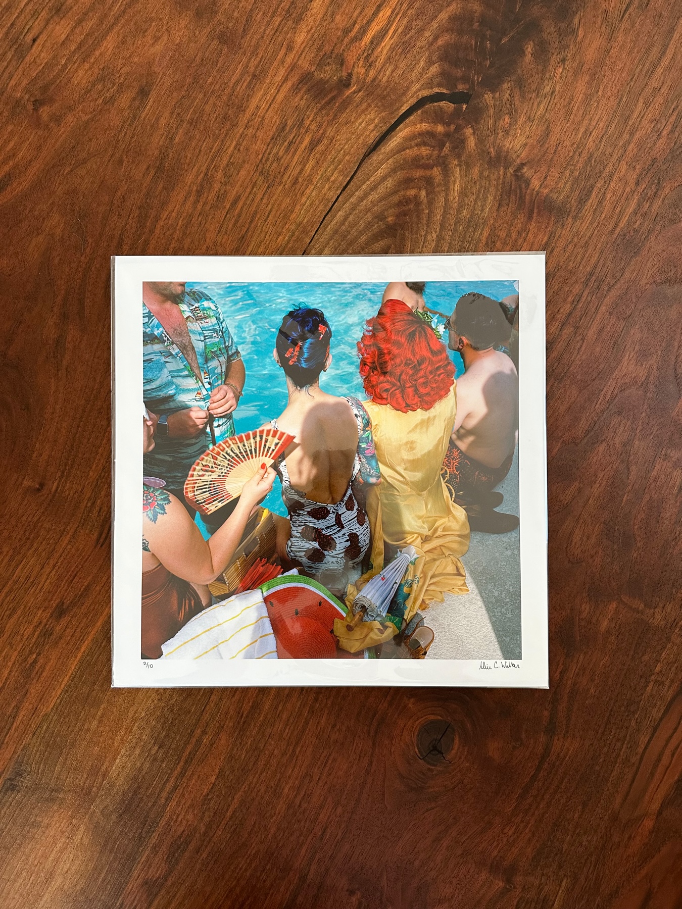 A colorful square photographic print enclosed in a clear plastic envelope.