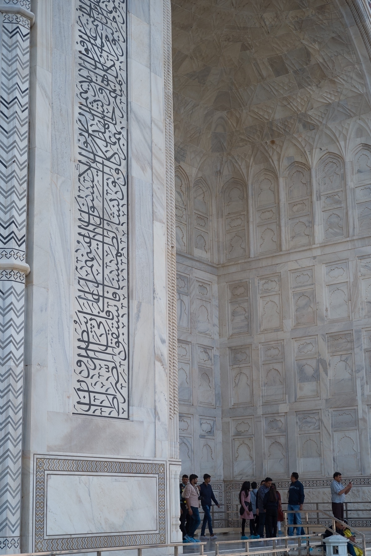 Main arch on the back of the Taj Mahal with inscriptions around it, and relief carvings on the inside.