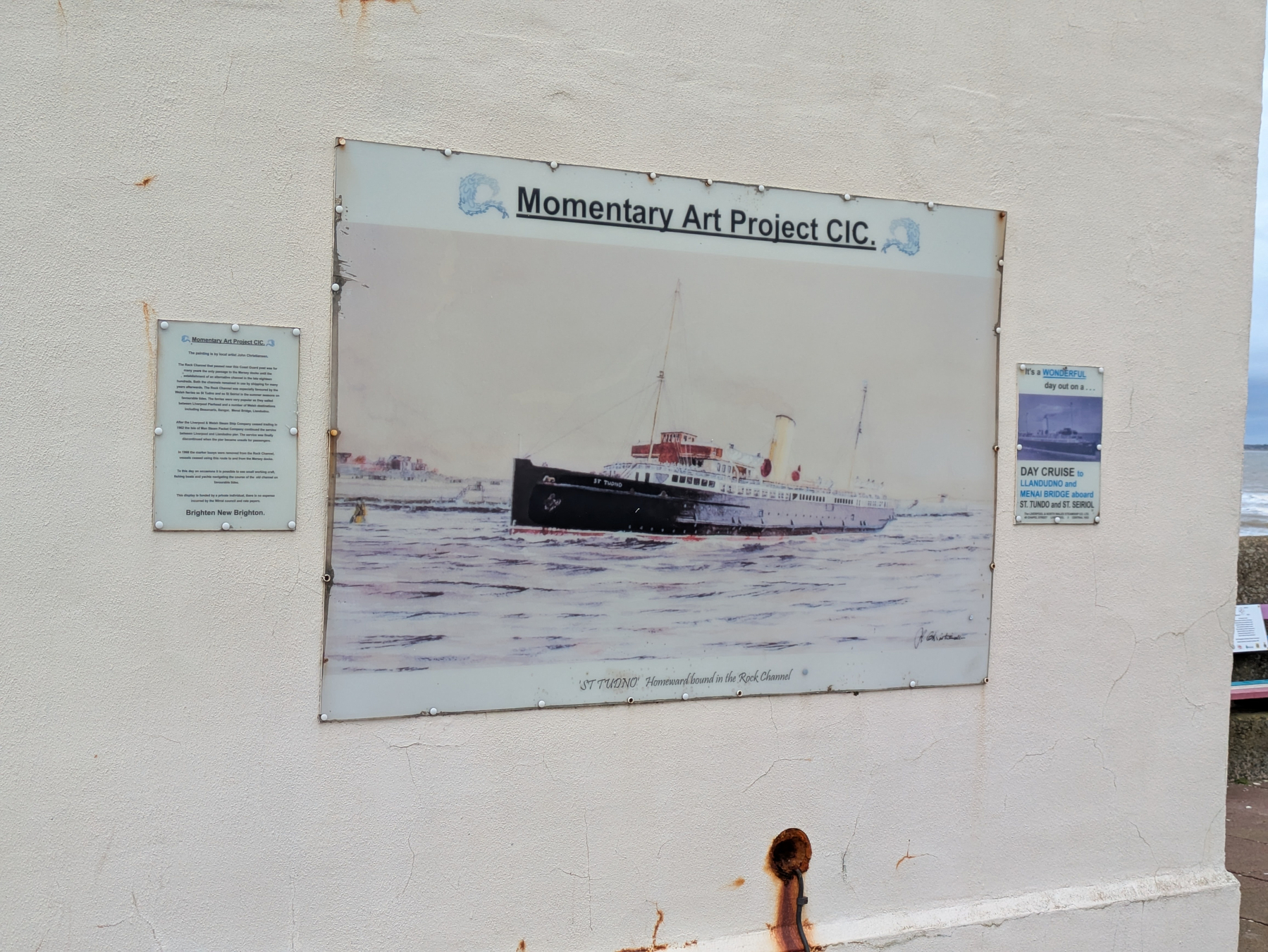 A nautical-themed artwork is displayed on a wall, featuring a historic ship at sea, accompanied by informational plaques.