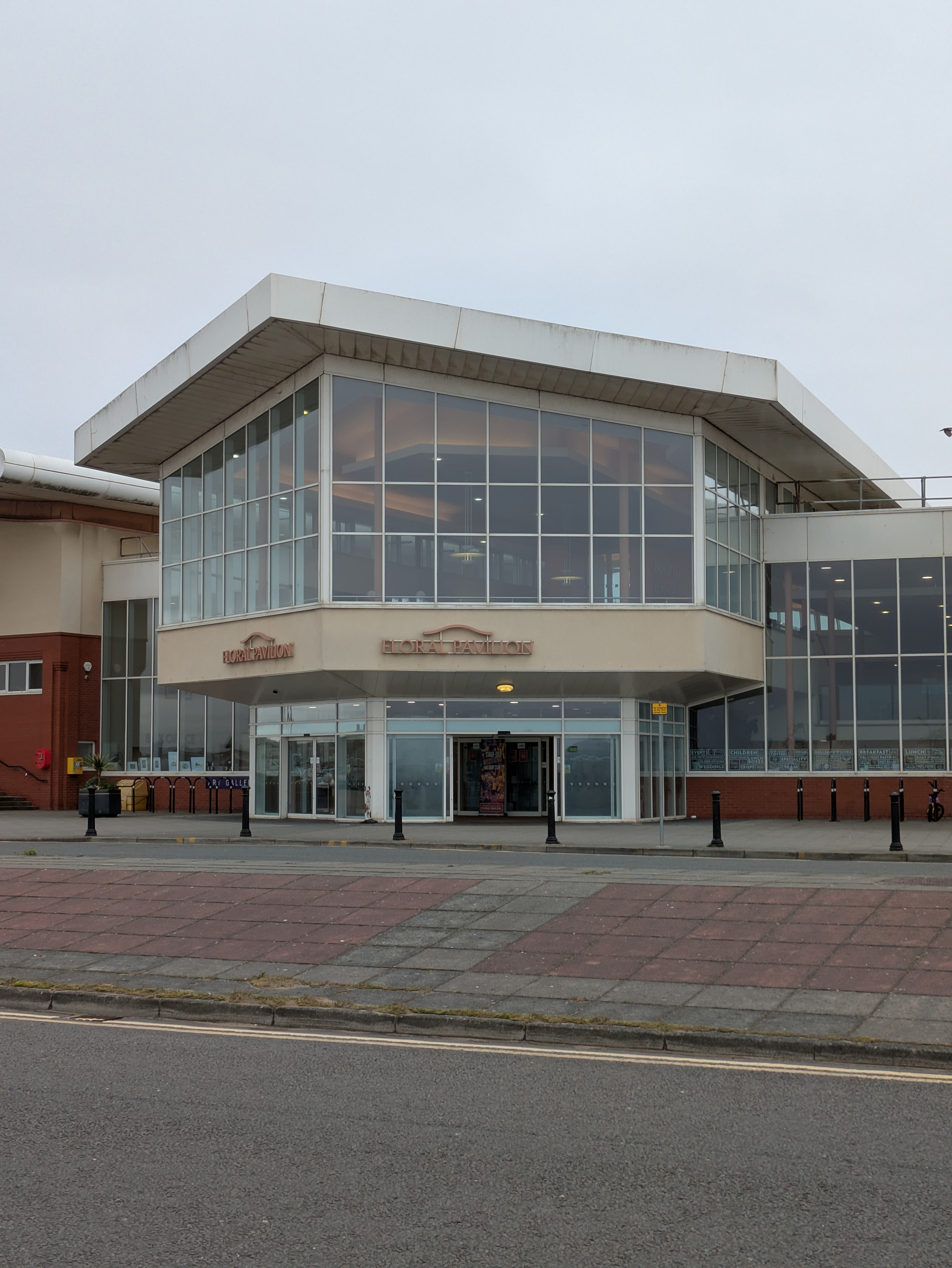 A modern building with large glass windows and a sign that reads Floral Pavilion on its facade.