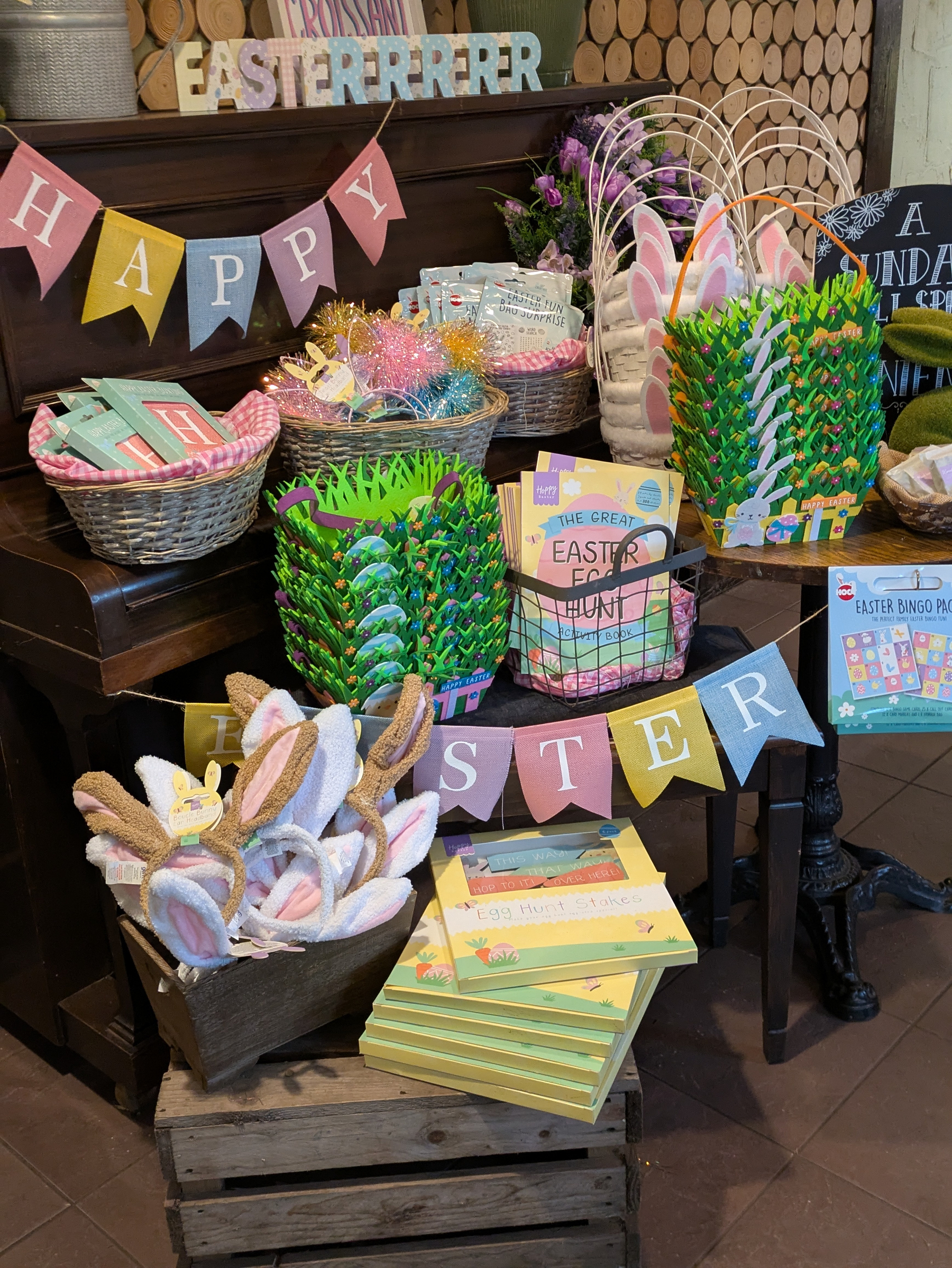 A festive Easter display features baskets with bunny ears, colorful decorations, and playful Easter-themed signs.