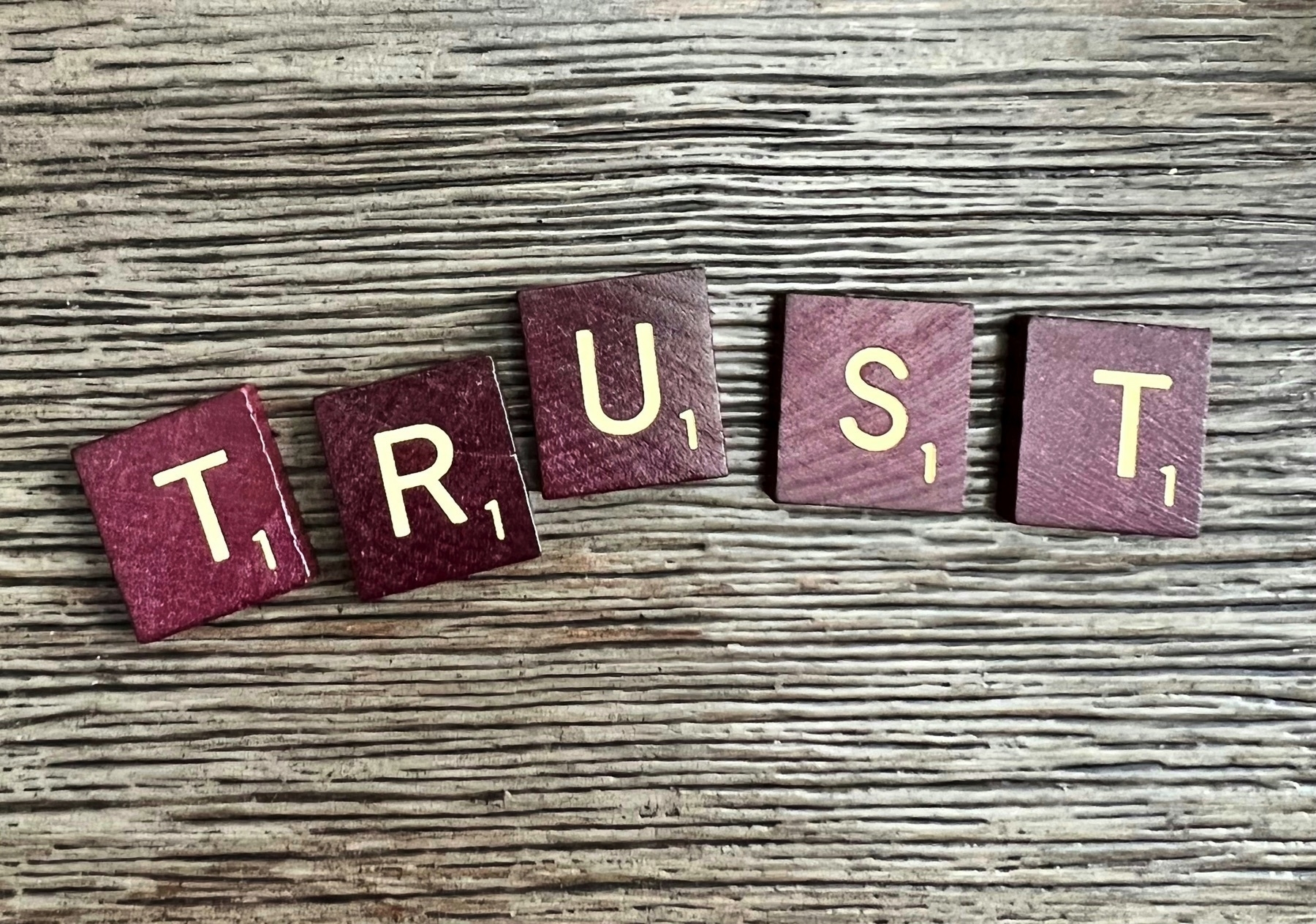 Scrabble pieces spelling out the word trust…