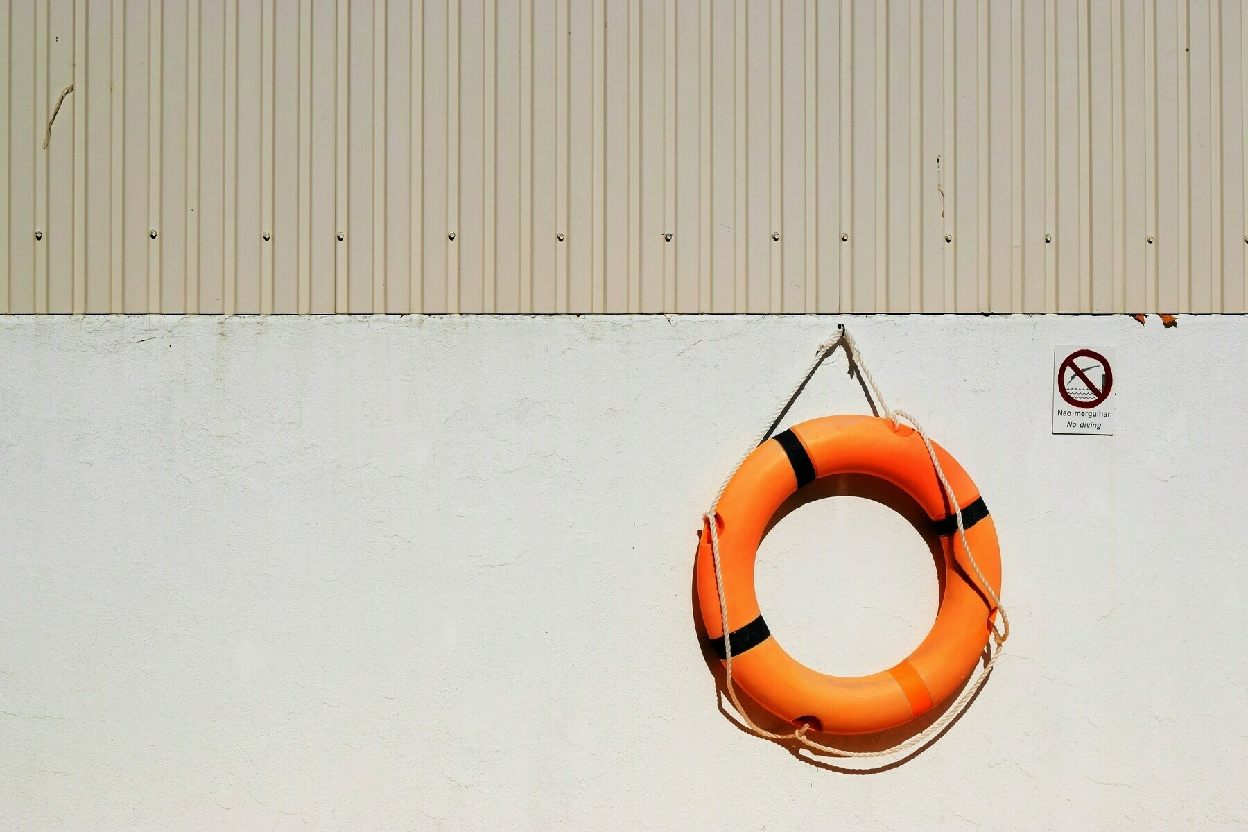 an orange life preserver ring hanging on a white wall