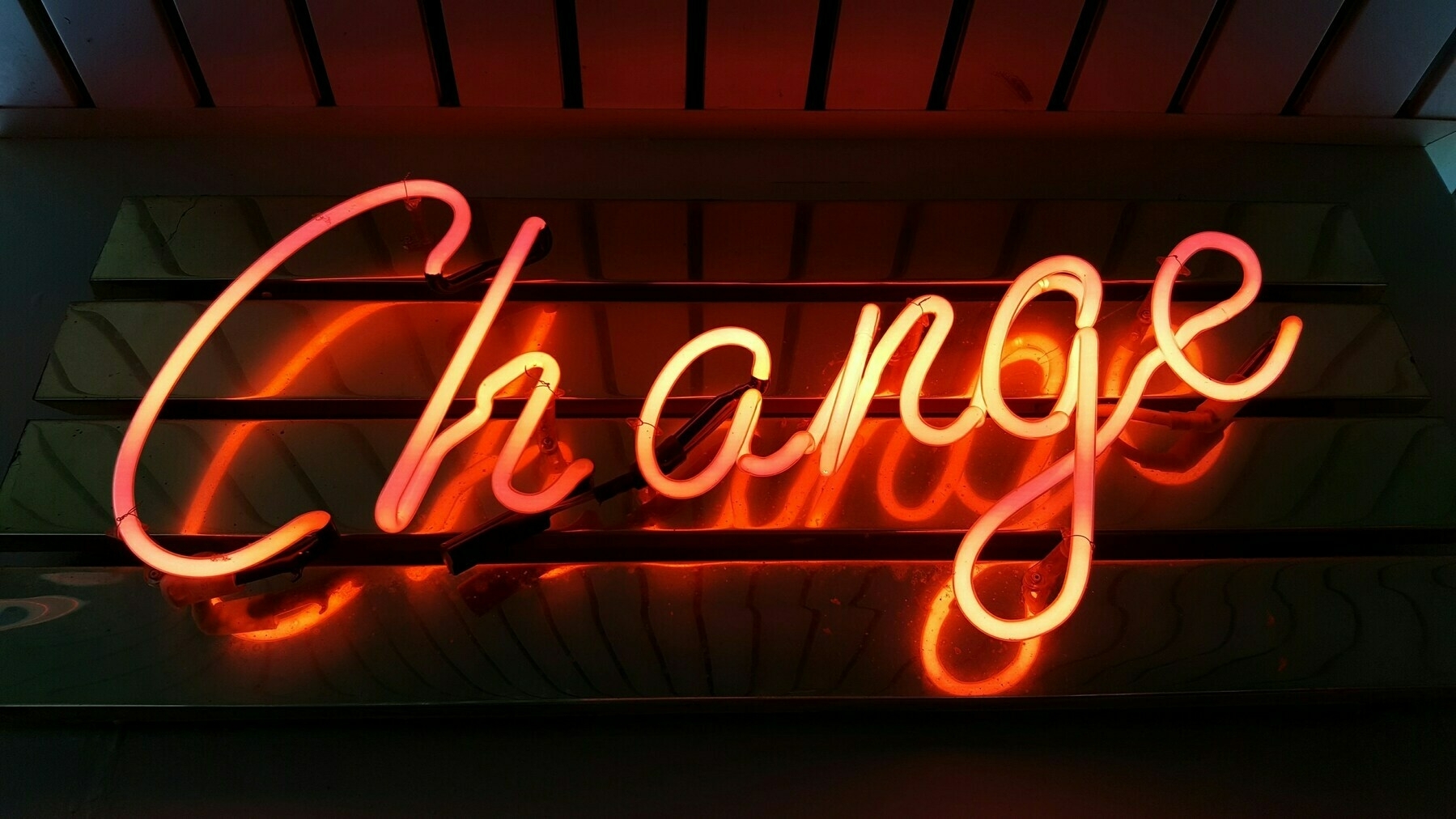 a neon sign that says change in cursive