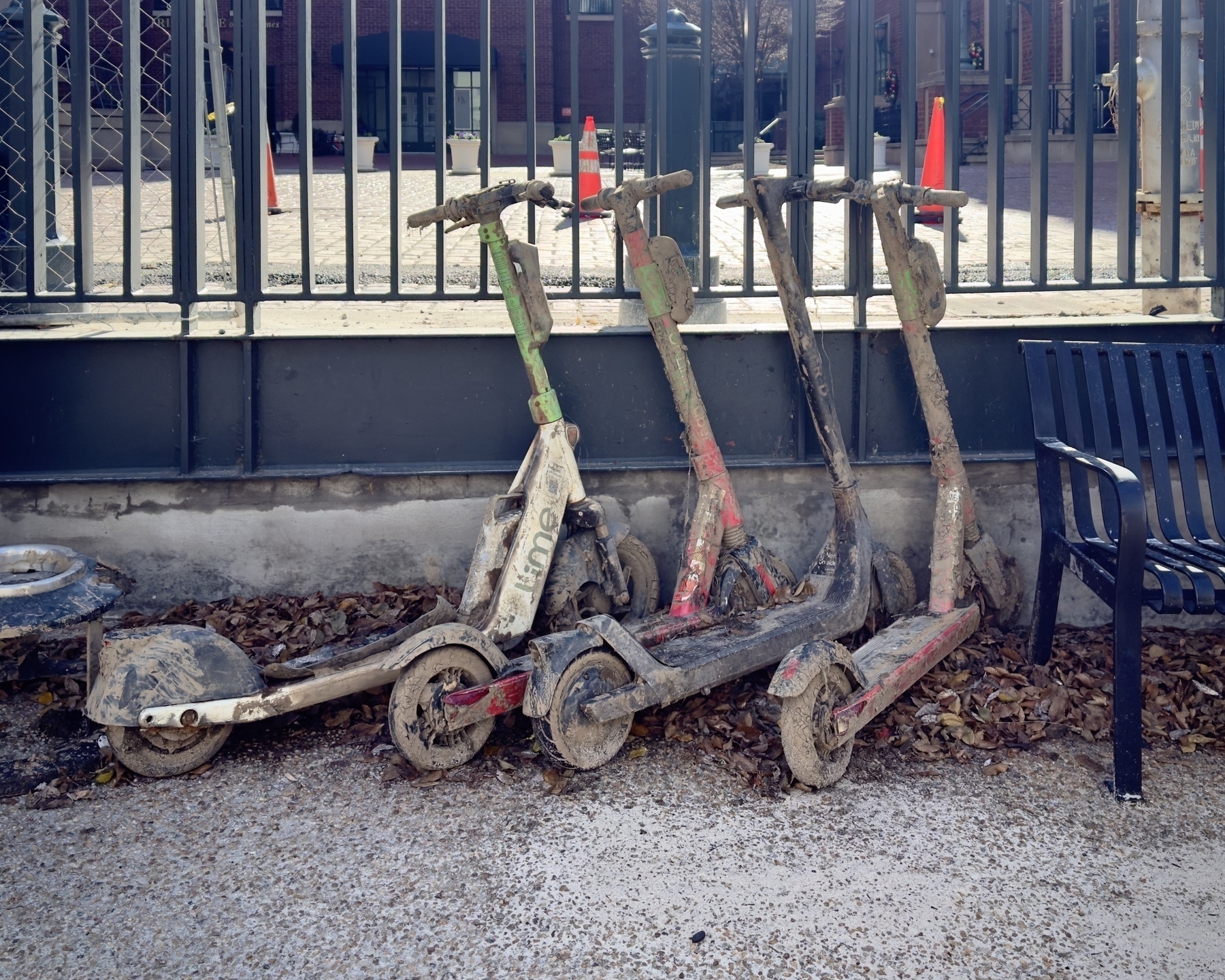 Four dockless rental scooters covered in dried mud, retrieved from a temporarily drained Kanawha Canal