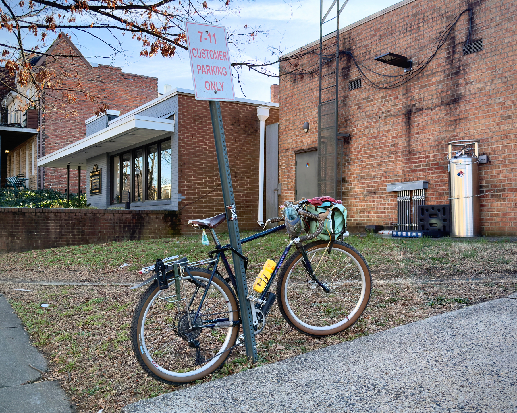 My bike locked up to a sign outside a 7-11 that reads “7-11 Customer Parking Only”