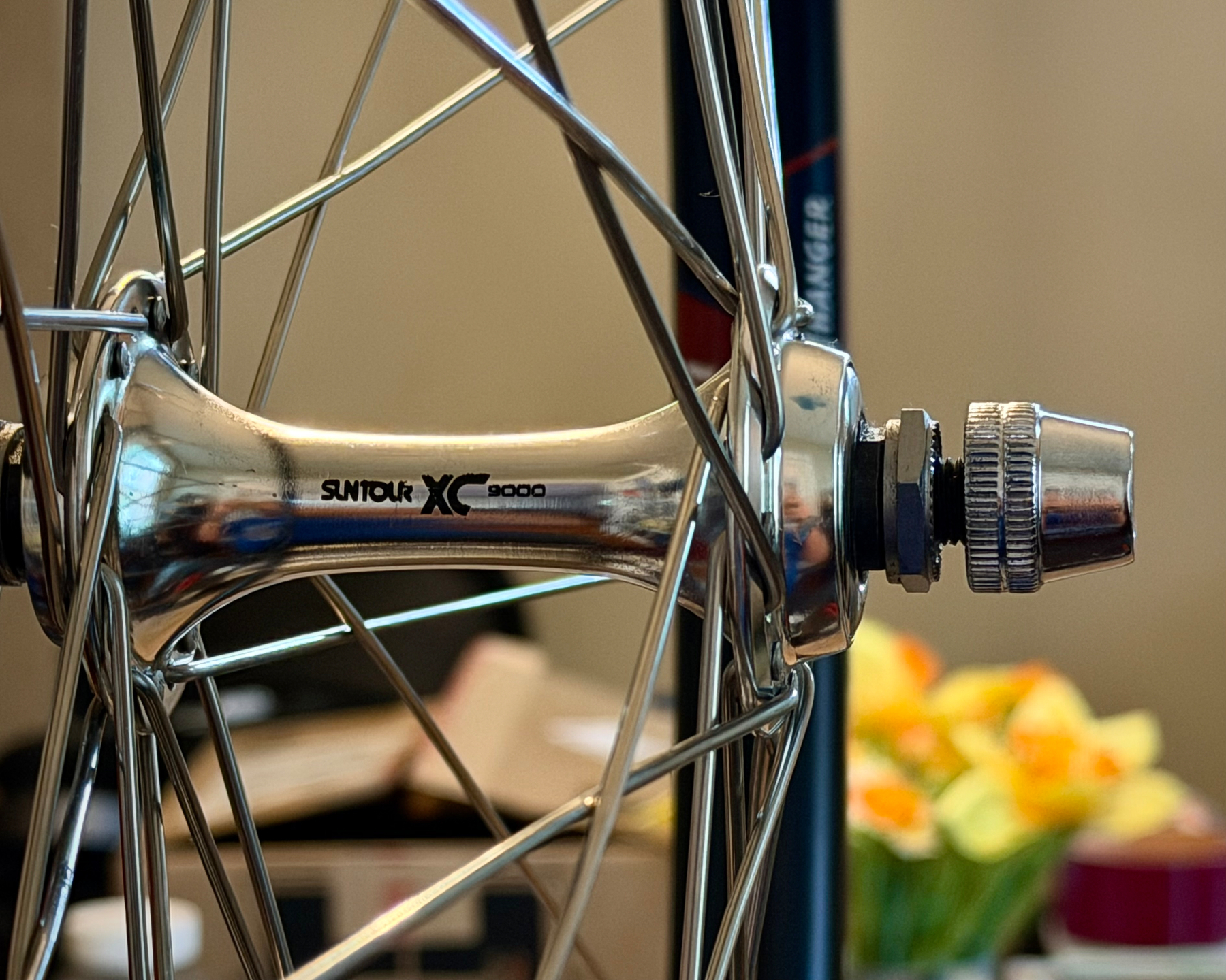 Shallow focus shot of the front Suntour XC9000 hub in a wheel I just built