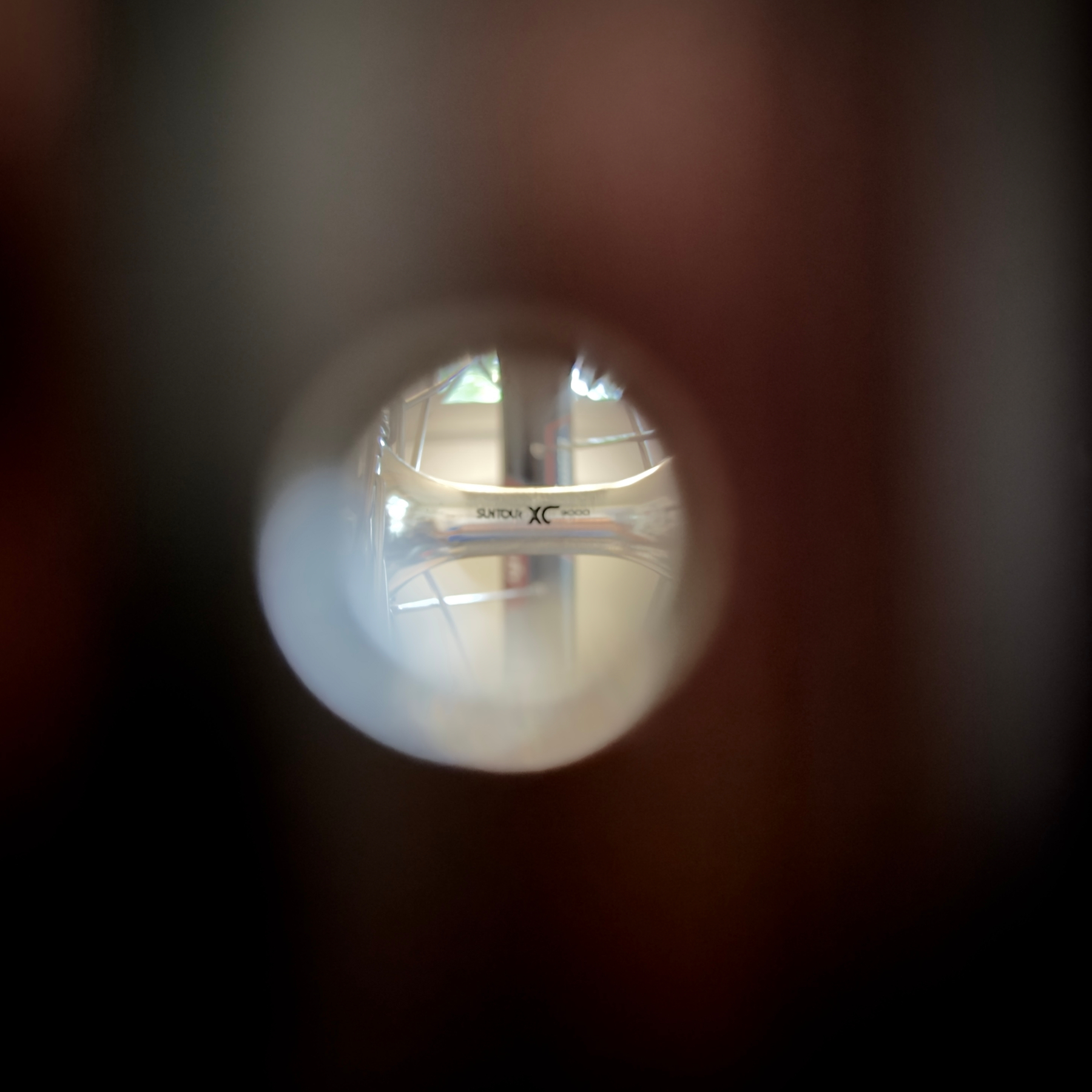 A view through the valve hole on a rim showing the Suntour XC9000 logo on the hub