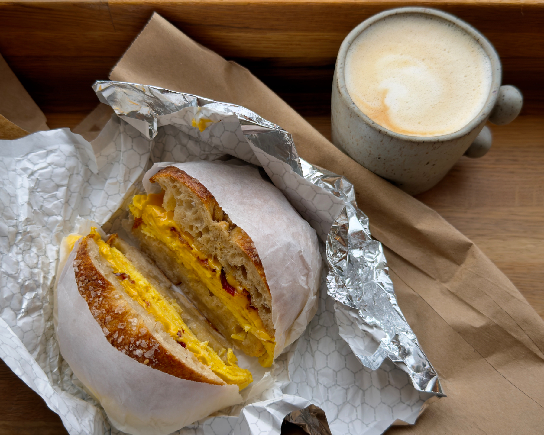 Bacon, egg, and double American cheese on a salt bagel with a masala flat white