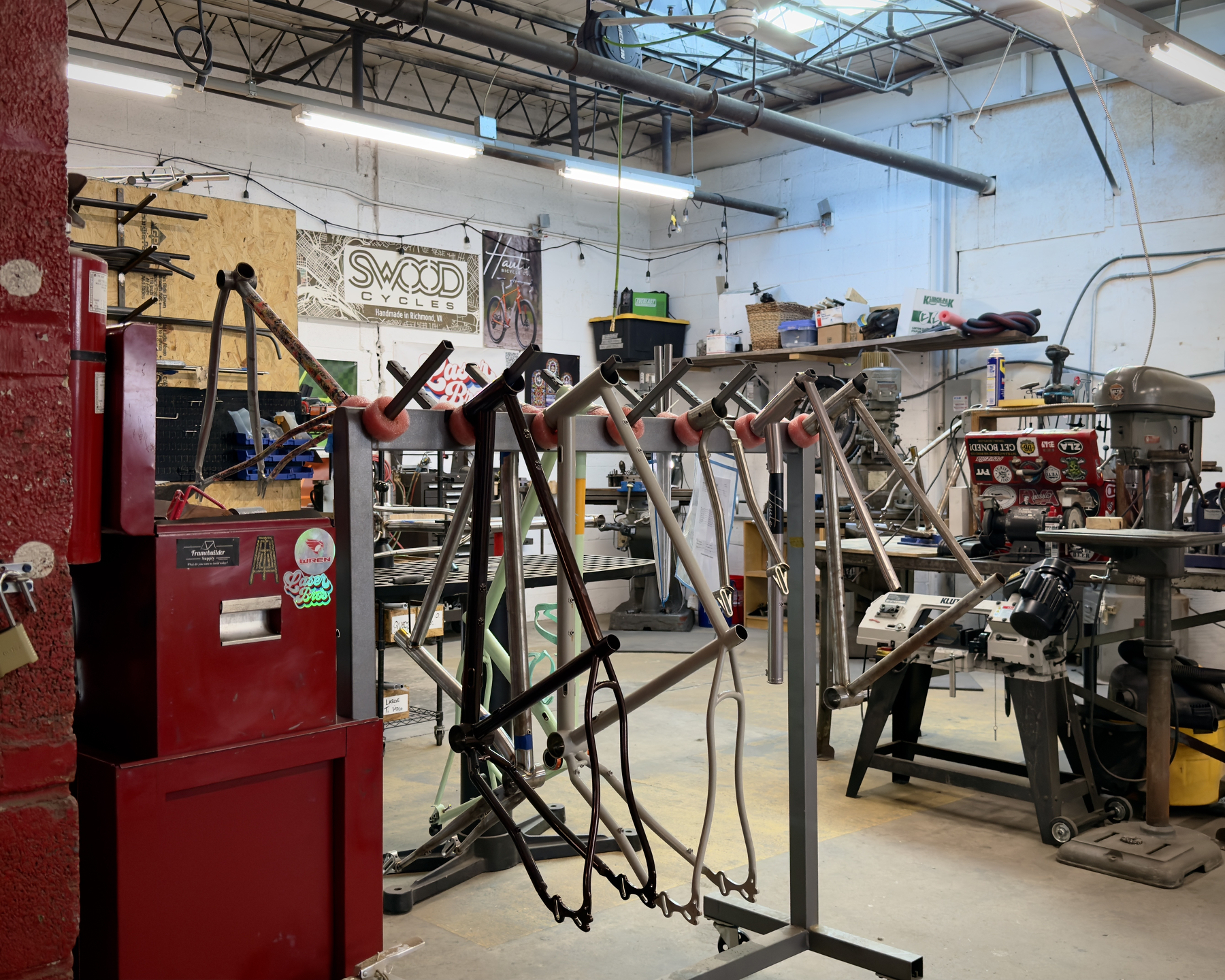a rack with multiple bike frames in multiple stages of completeness