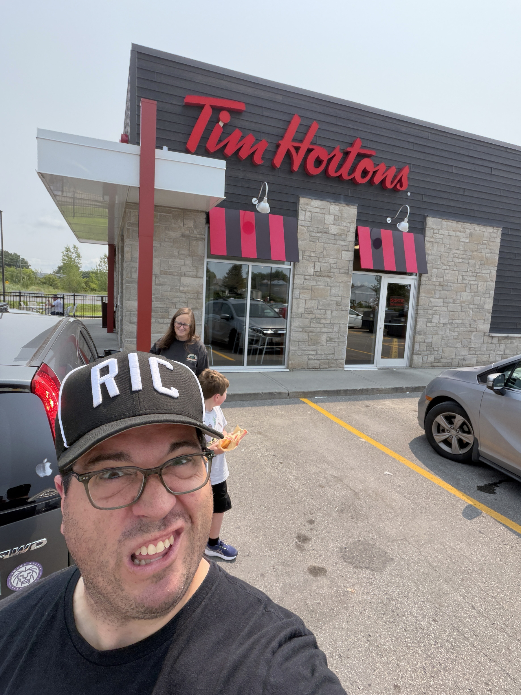 me making a weird face in front of a Tim Hortons