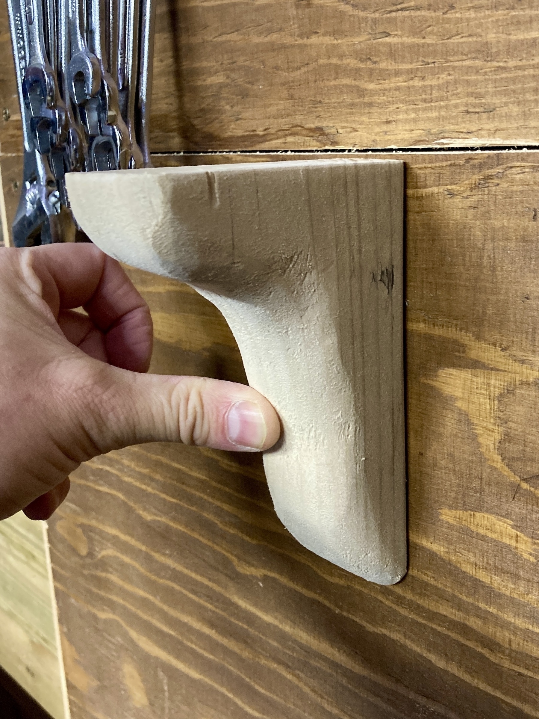 A shelf bracked carved from a piece of wood, held against the wall by my thumb. 