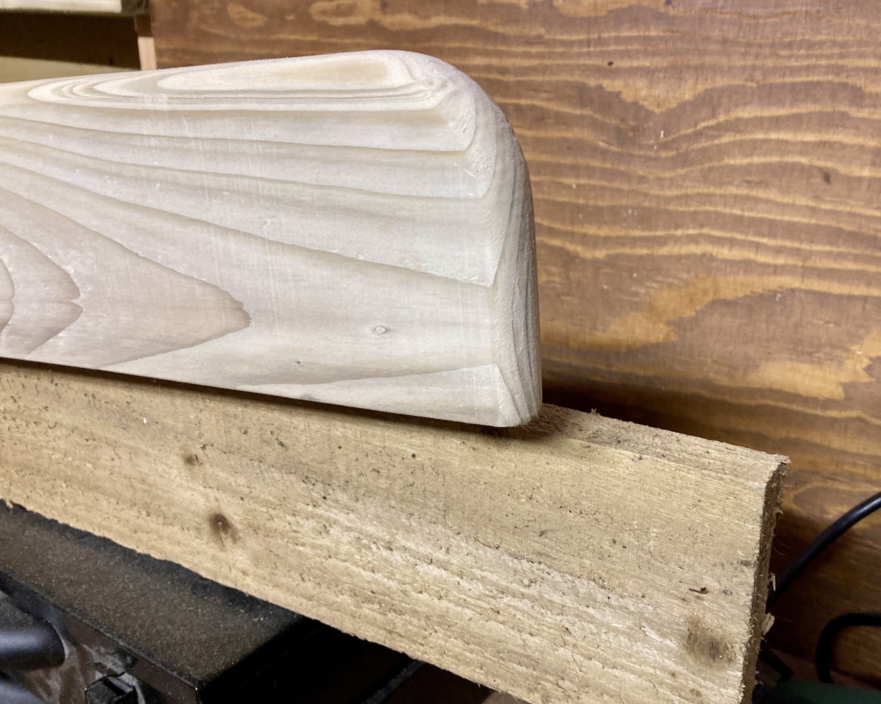 Two planks of wood, one cut and sanded into a nice shelf, one rough from the sawmill, together to show a before and after. 