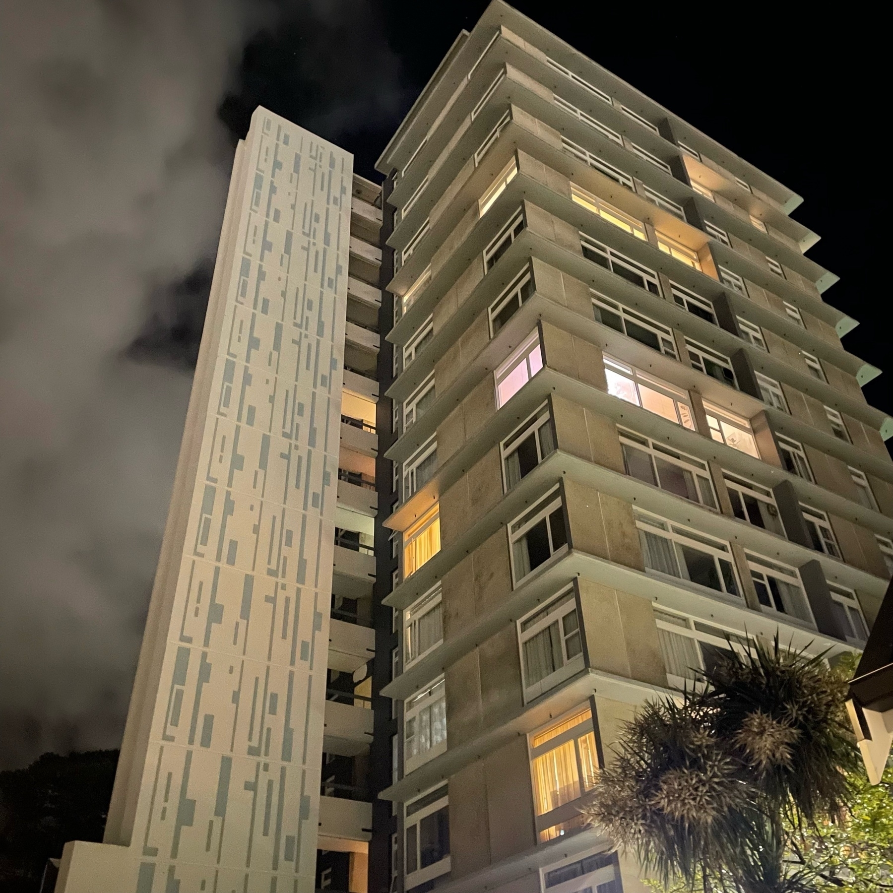 Nighttime view of a modernist tower block. 