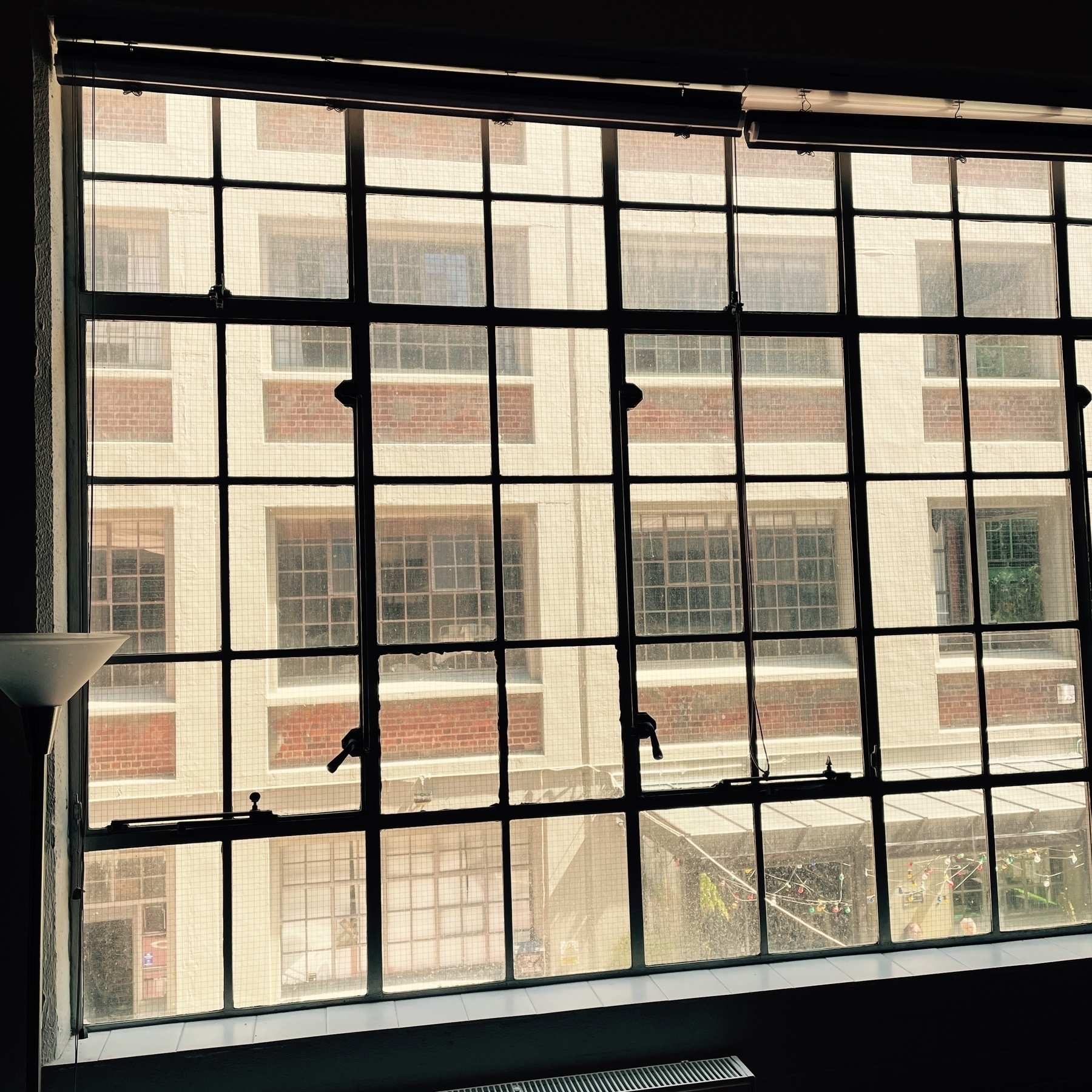 Loft apartment iron window frames. View of similar apartment block across courtyard. 