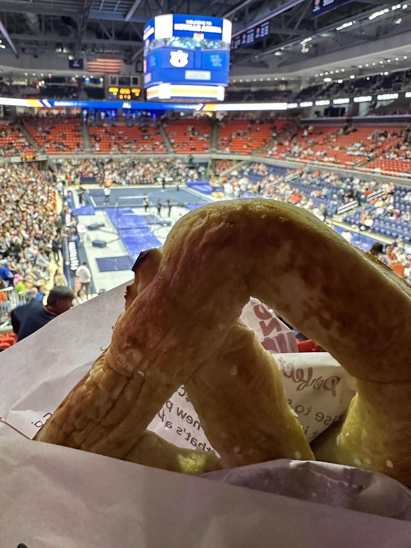 A soft pretzel with an arena in the background