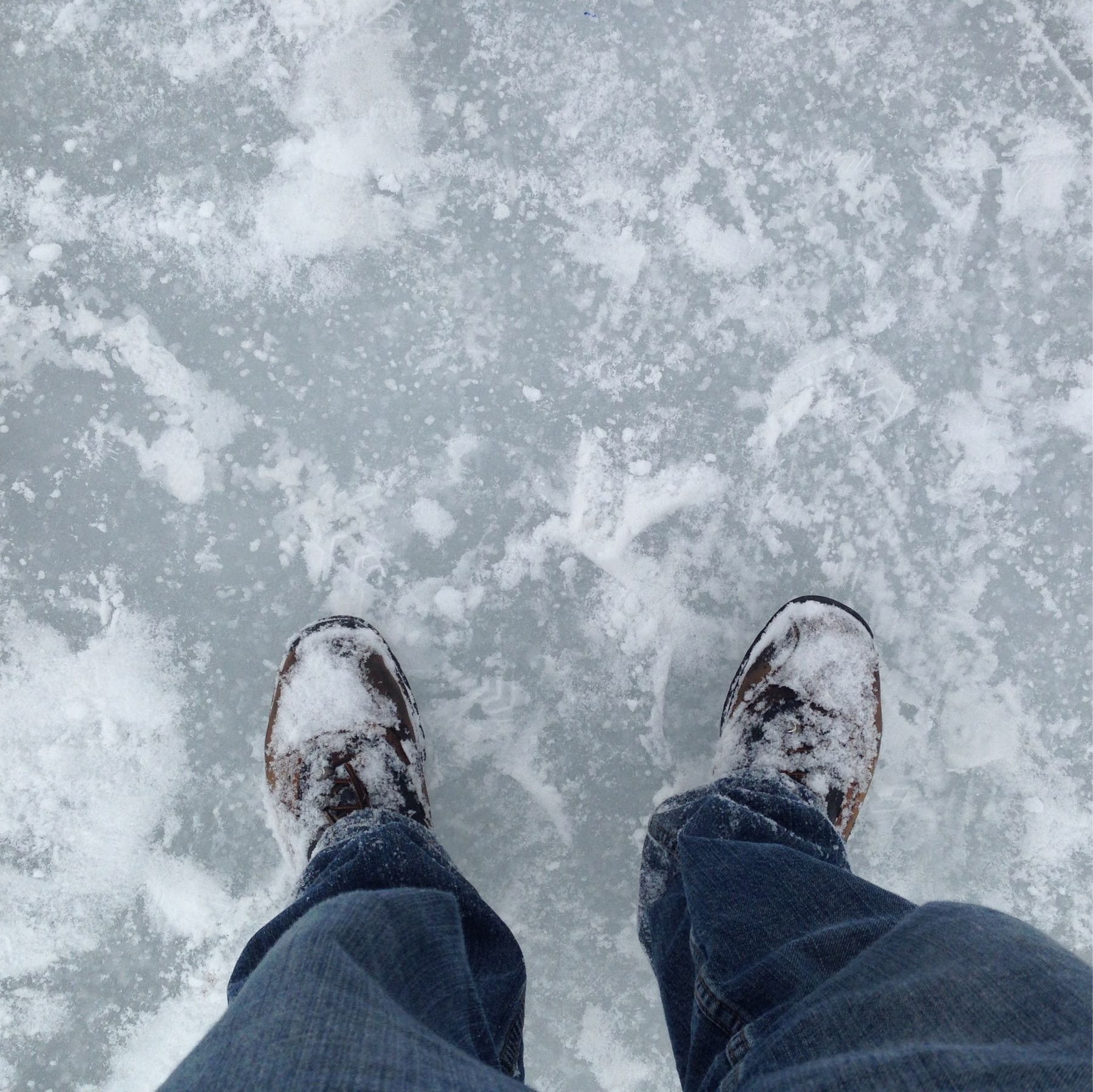 Snow-covered boots standing on a frozen lake