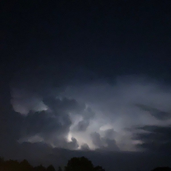 Lightening fills a thunderhead cloud at night