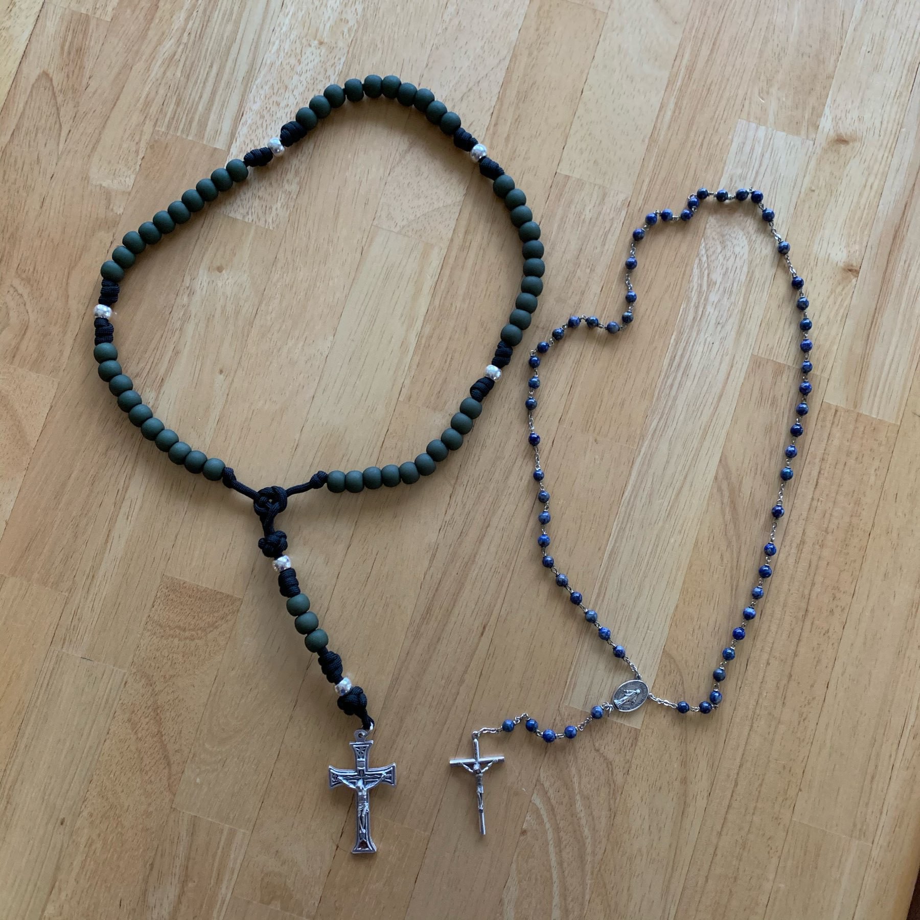 Rugged rosary with a normal size rosary on a table. 