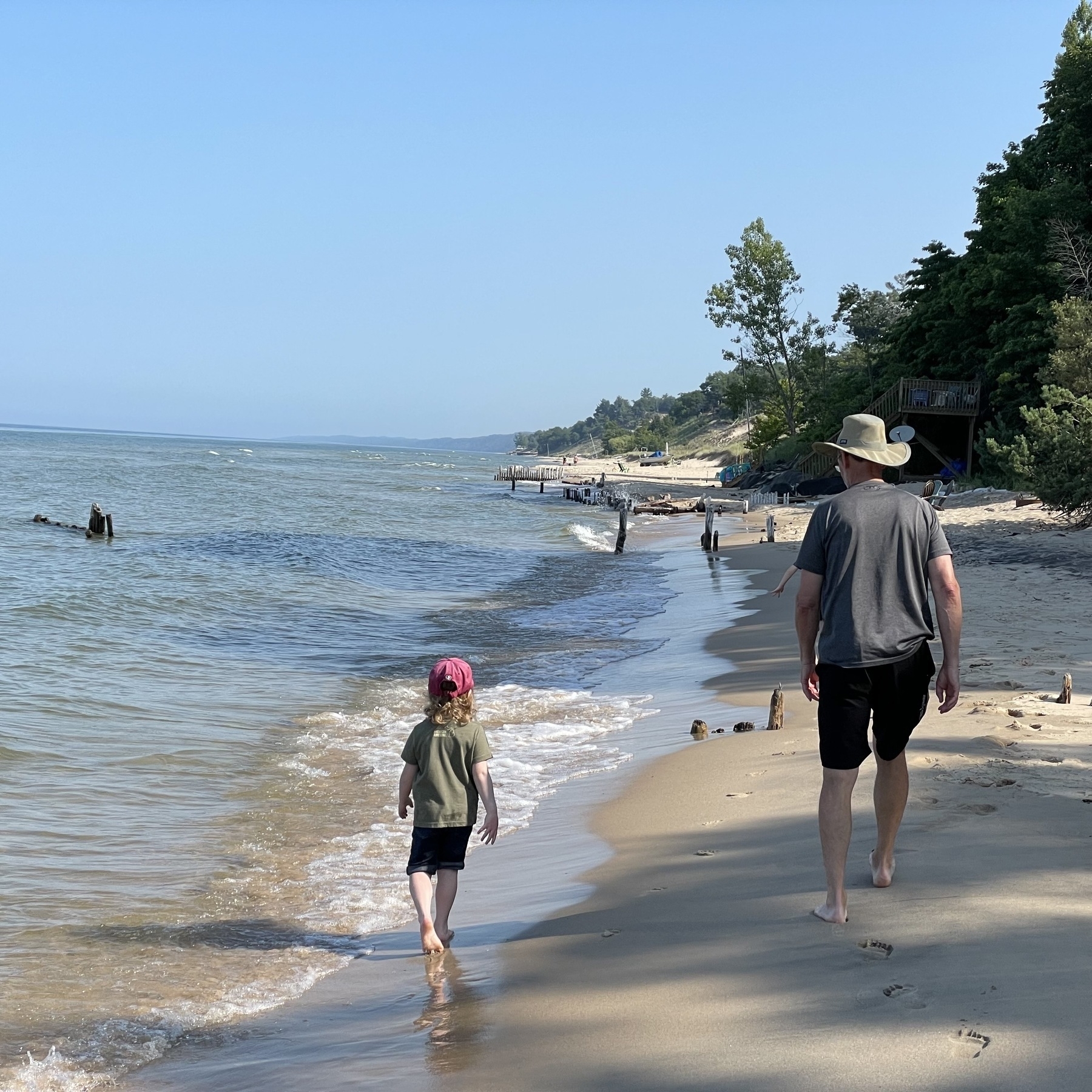 Grandfather and granddaughter walk along the beach