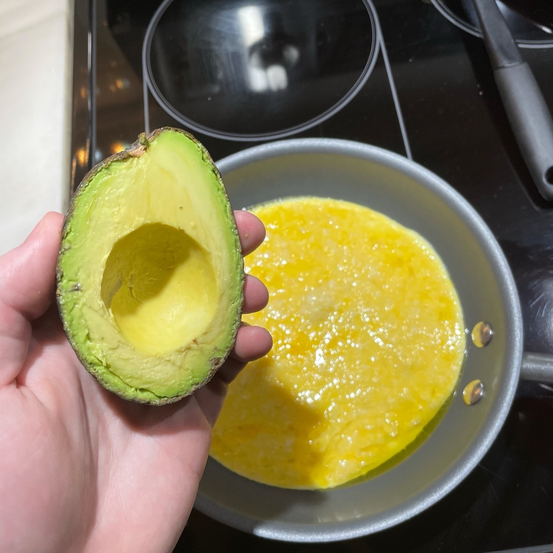 Eggs in frying pan with avocado