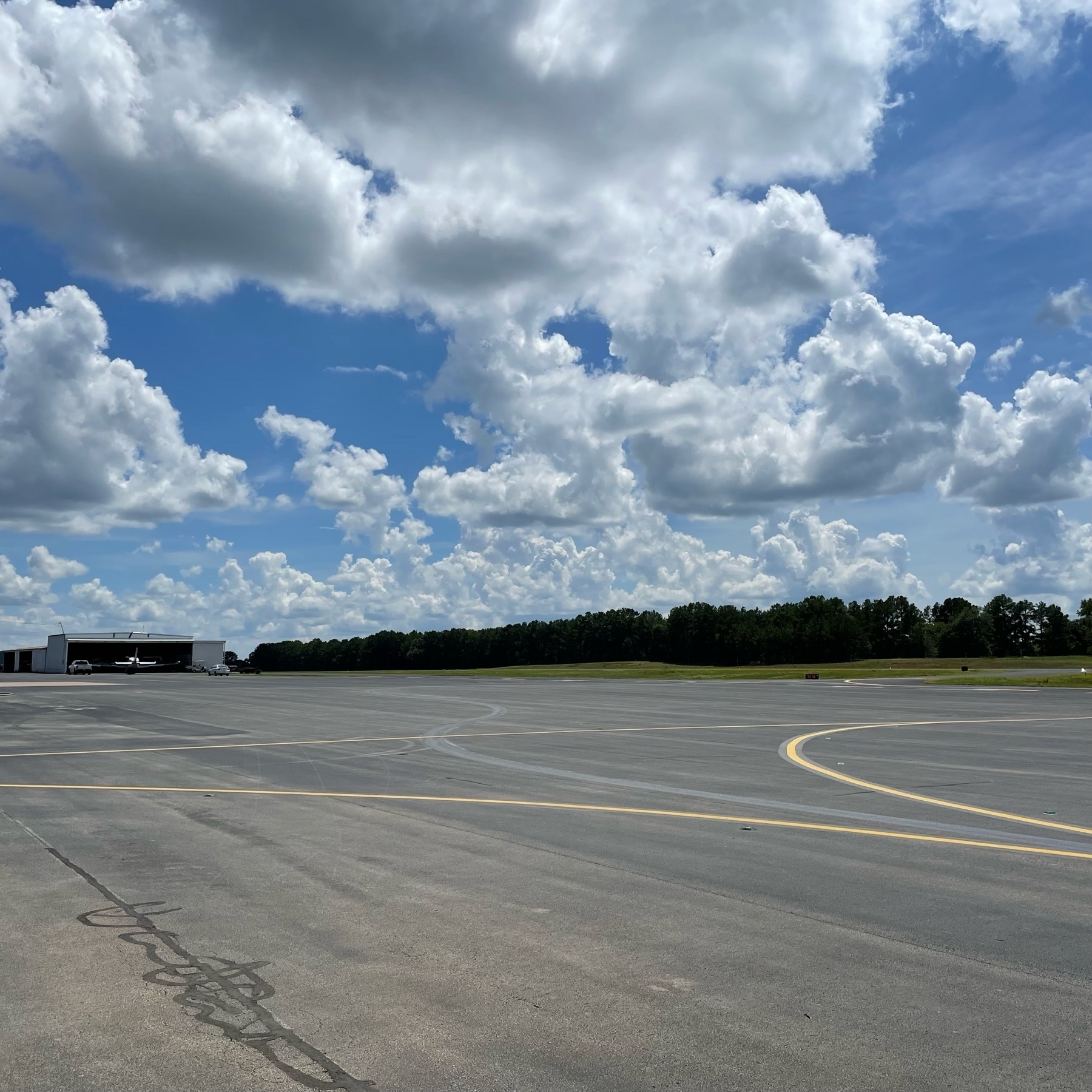 Clouds and sunny sky over an airport ramp