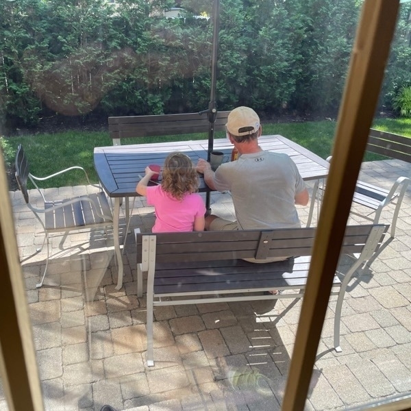 Grandfather and granddaughter, eating on the patio