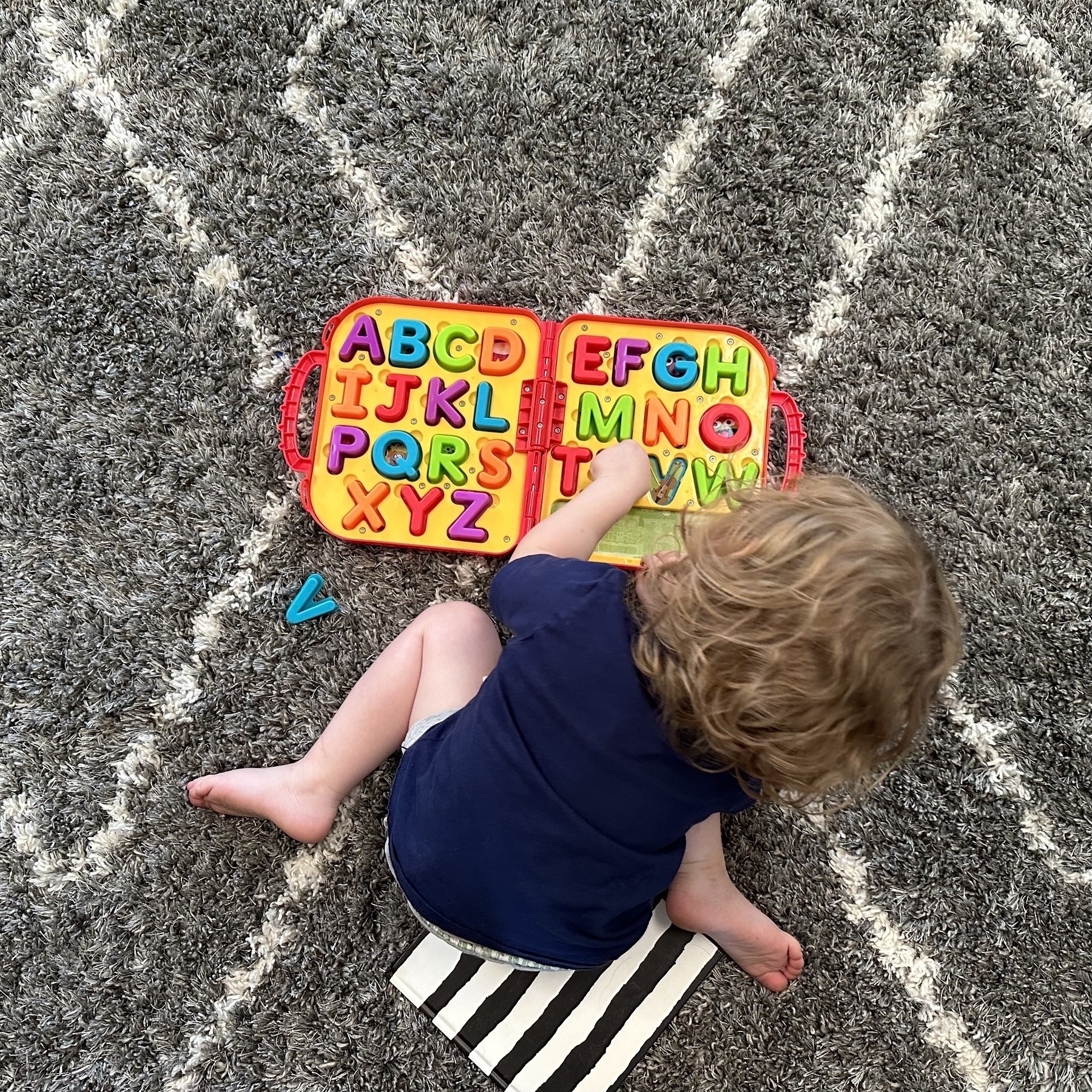 Daughter plays with letters on carpet