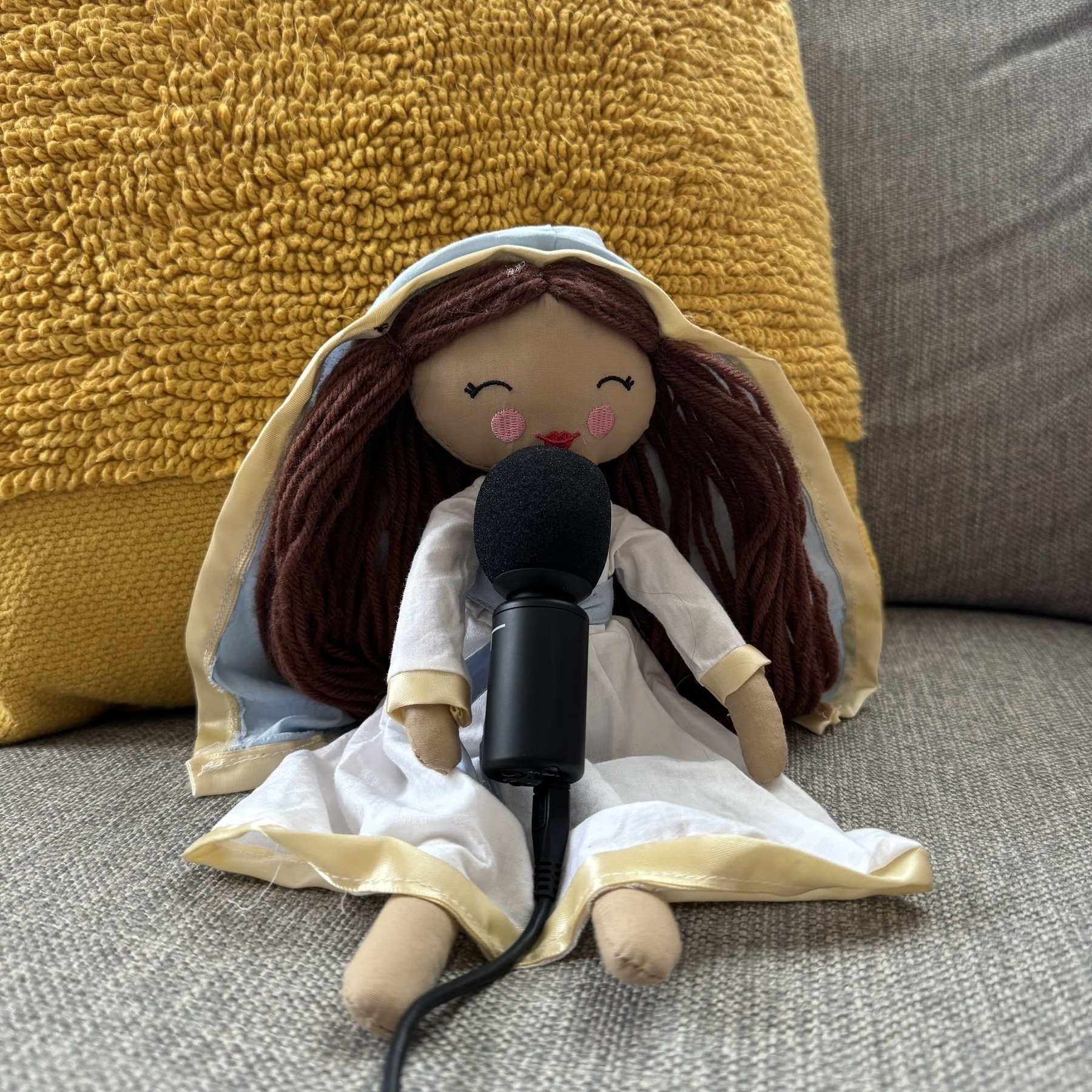 Mary doll holding a microphone