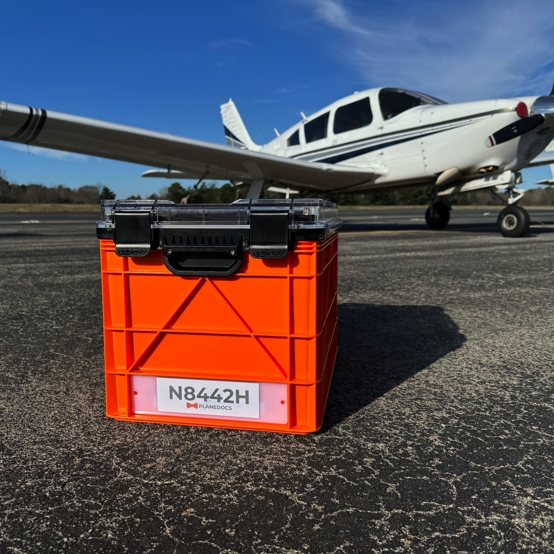 Orange storage tote on the ramp by an aircraft