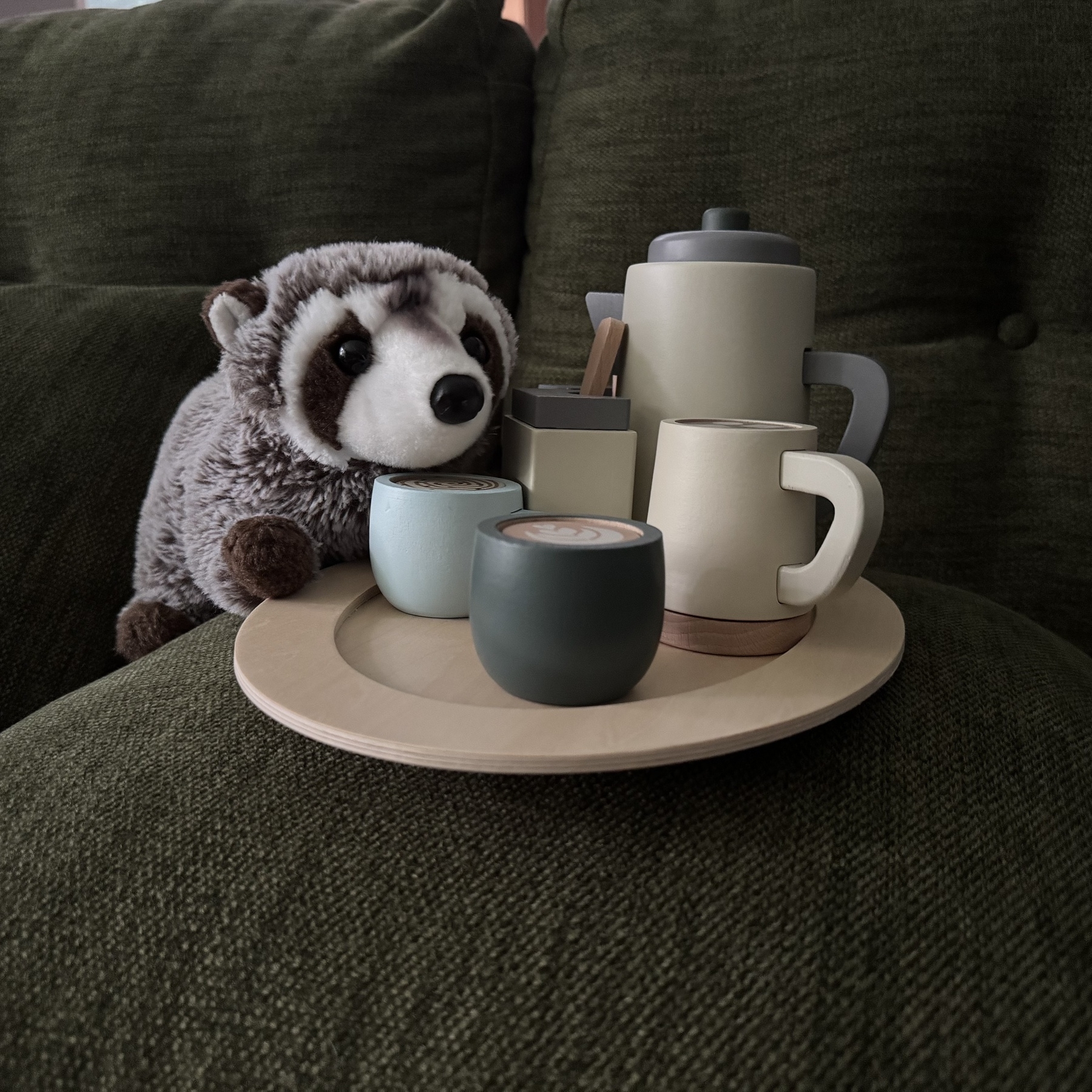 Stuffed raccoon drinking hot chocolate and coffee