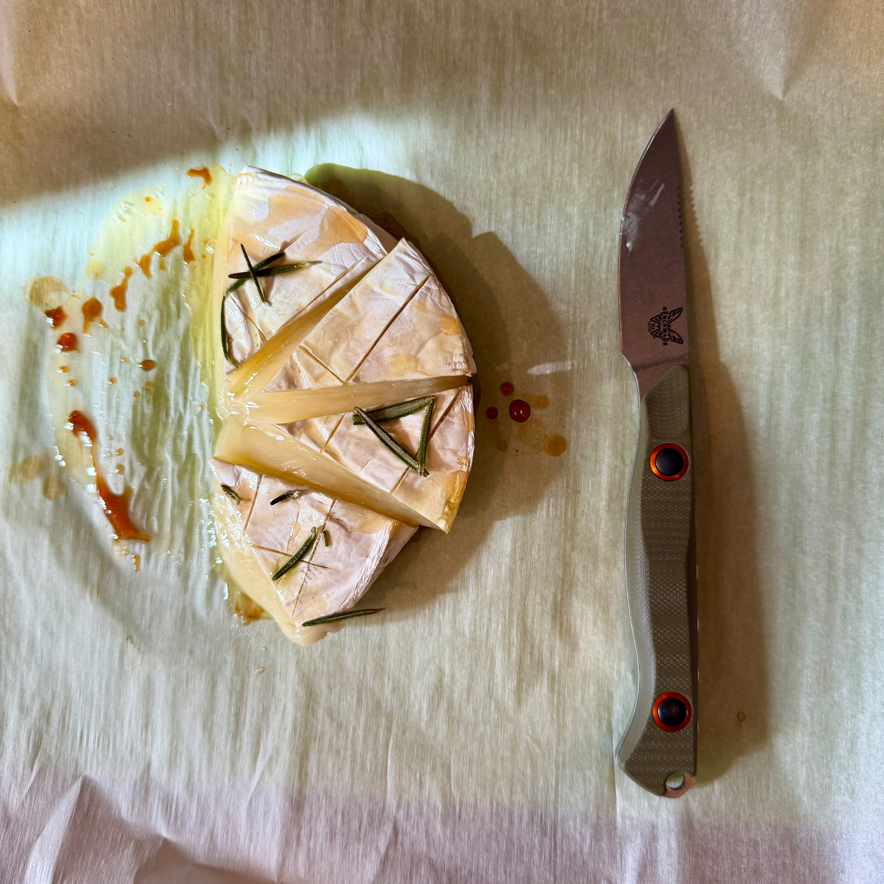 Baked brie on cutting board with Benchmade fixed blade