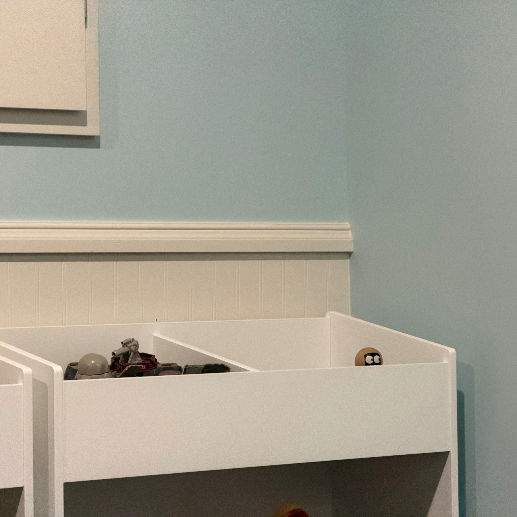 Toy robot peaking over a shelf