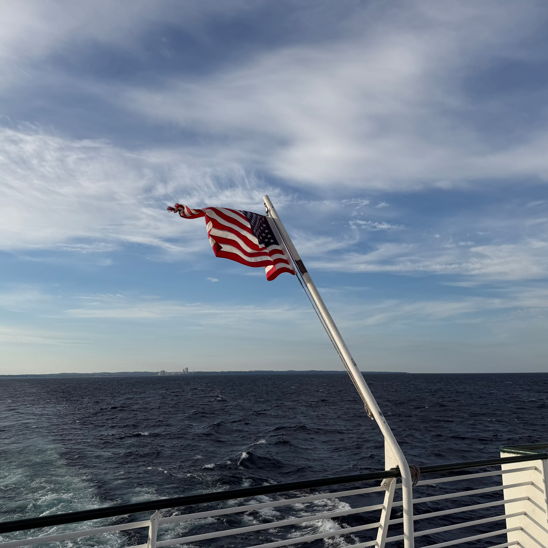 Vessel’s flag billowing with the Lower Peninsula fading behind us.