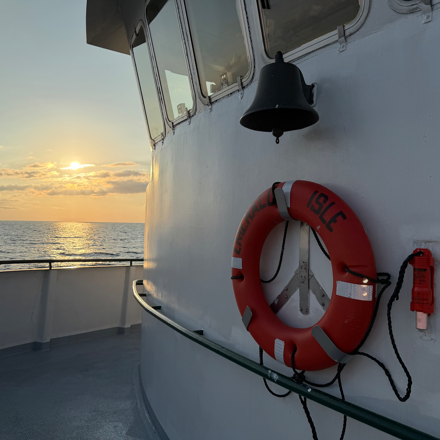 Sunset over Lake Michigan from the upper deck of M/V Emerald Island with pilothouse in view.