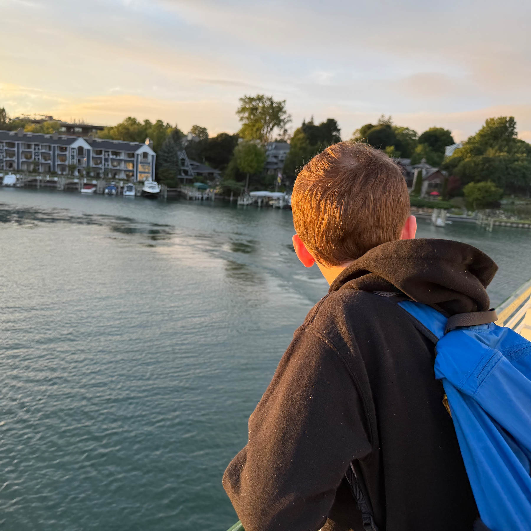 Benedict watching the ferry maneuver back into the Charlevoix dock over a glassy Lake Charlevoix.