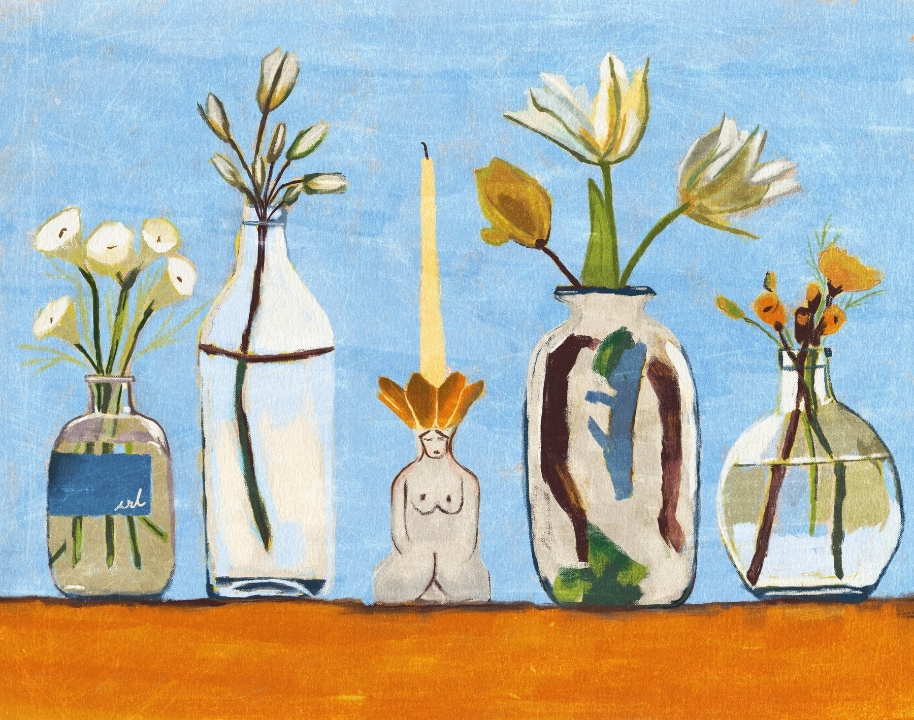 Several decorative vases with flowers and a candle featuring a figurine are arranged on a wooden surface against a blue background.